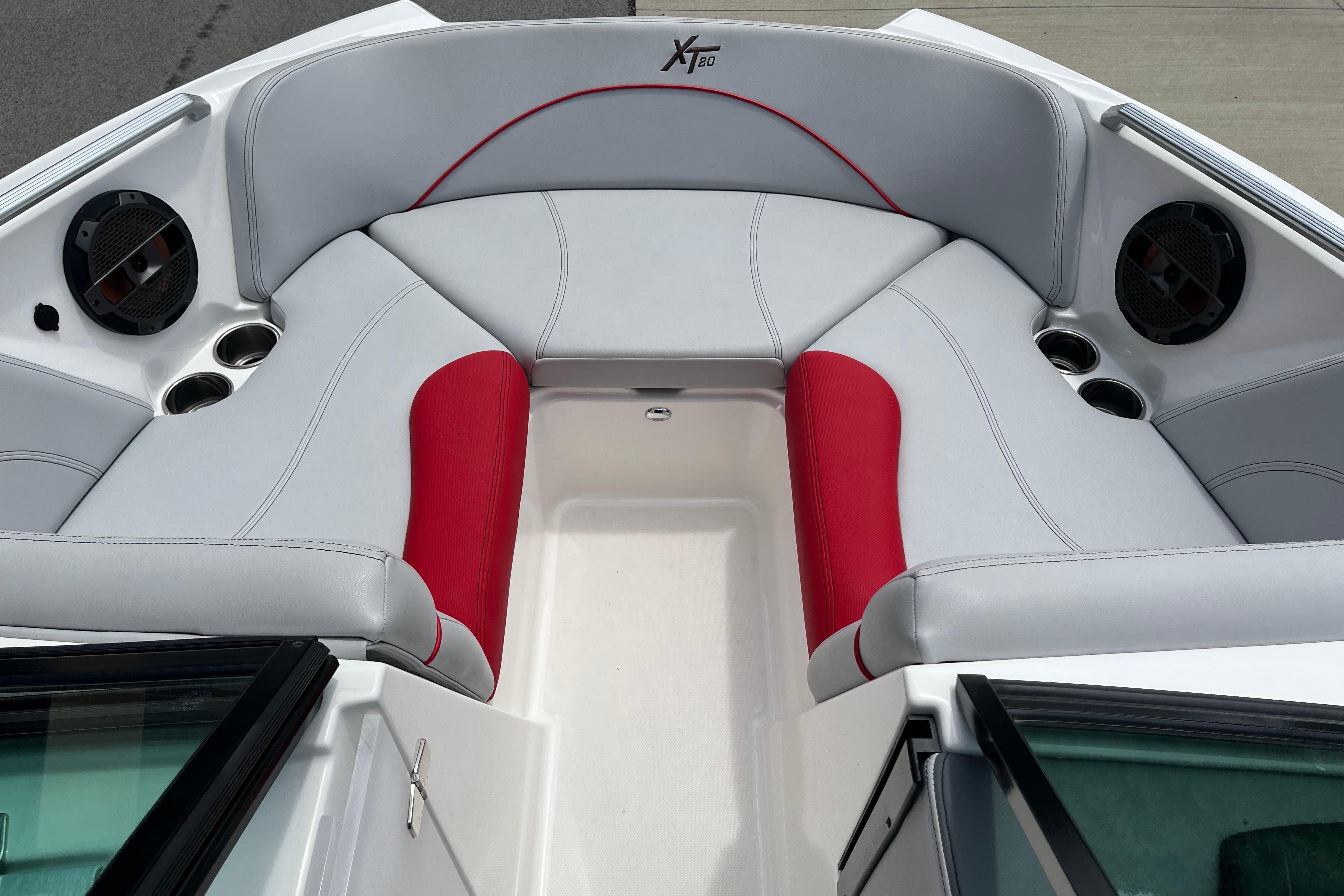 2019 MasterCraft XT20 boat interior with red and gray seating, cup holders, and speakers.