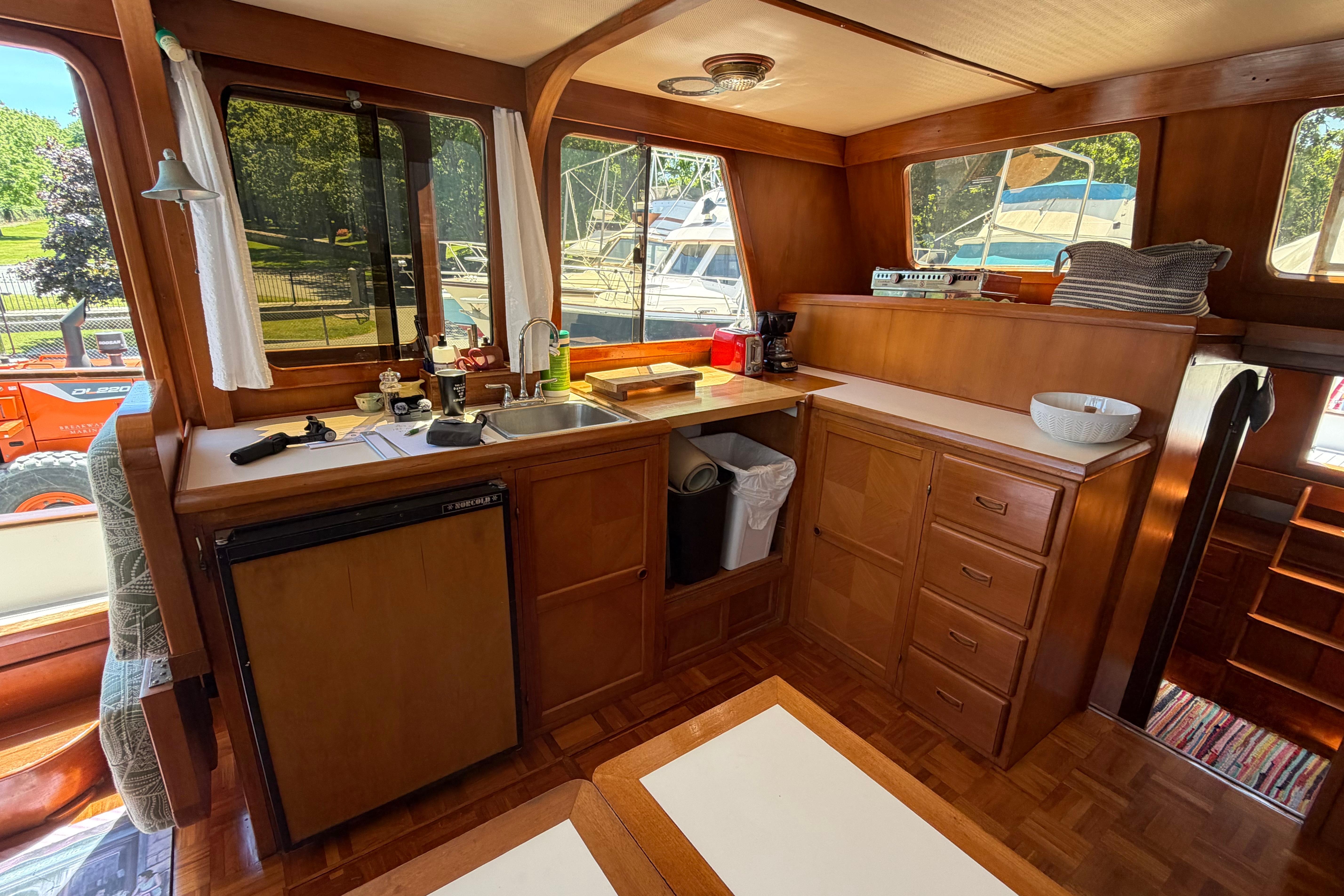 Interior of 1987 Marine Trader 36 yacht with wooden cabinetry and kitchen amenities.