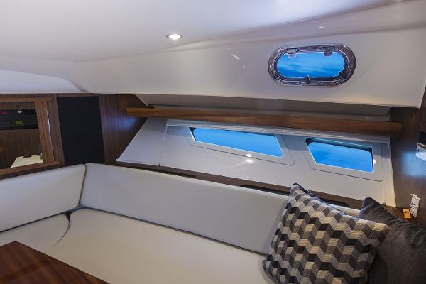 Manufacturer Provided Image: 2019 Pursuit OS 355 Offshore cabin interior with white seating and ocean view windows.