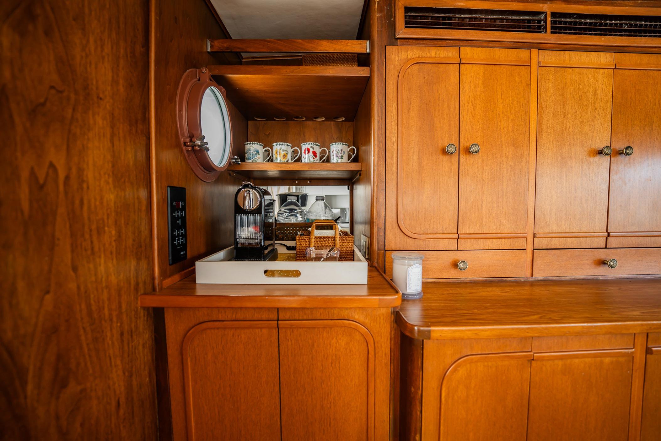Vintage 1972 Trumpy 72 Motor Yacht interior with wooden cabinetry and coffee station.