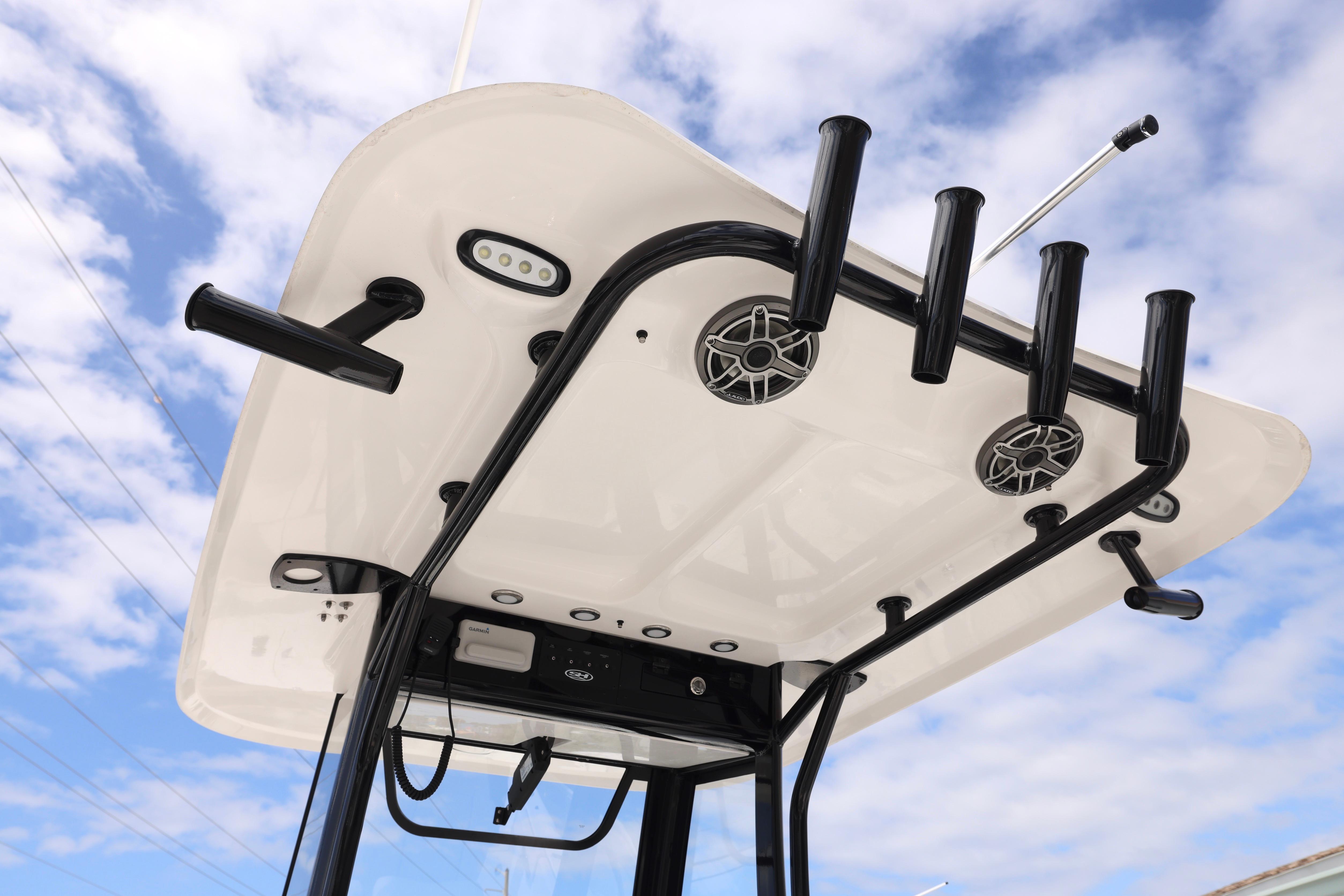 2026 Sea Hunt Gamefish 25 T-top with rod holders and speakers against a blue sky.