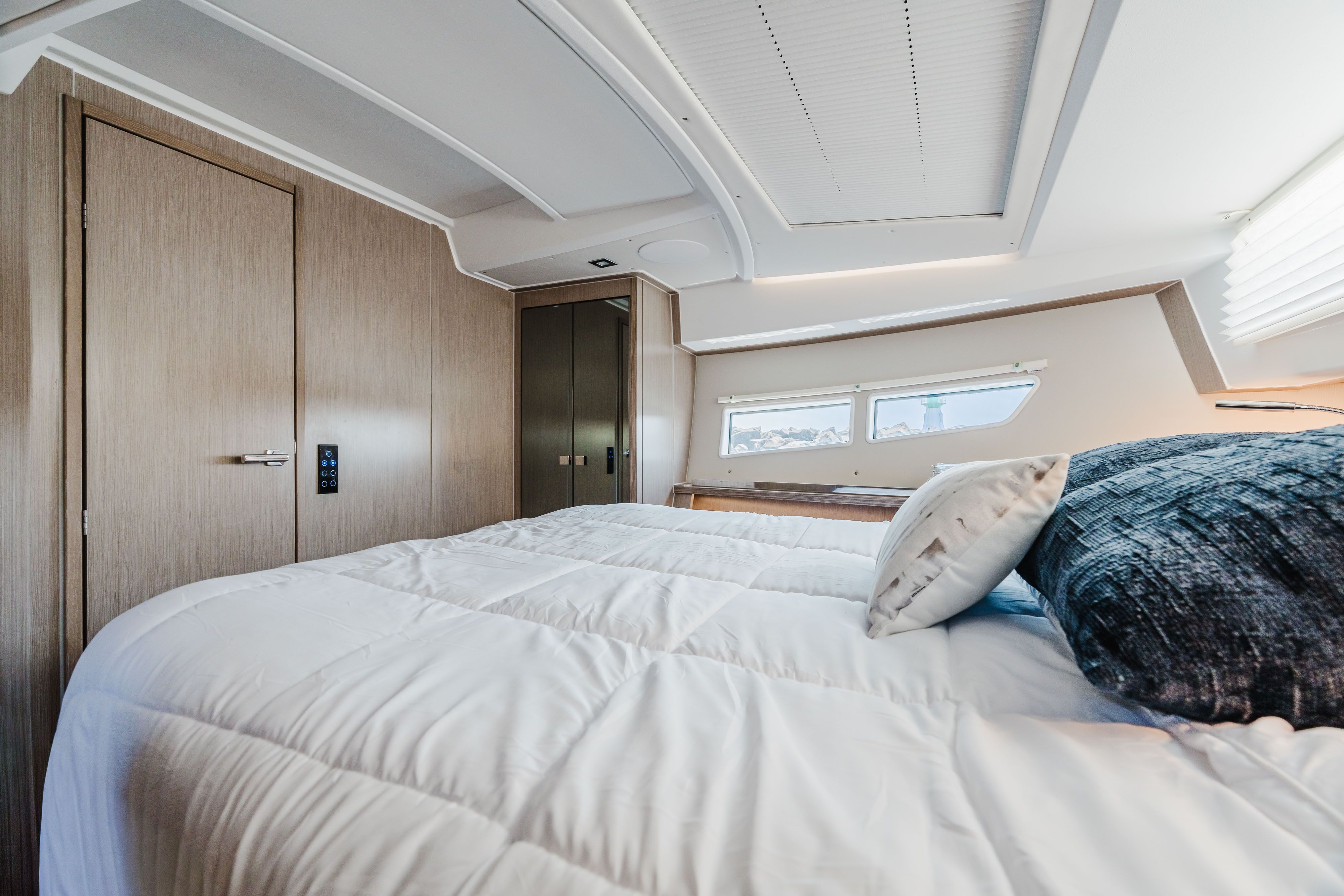 Sealine C335V 2023: Luxurious bedroom with modern design and large windows.