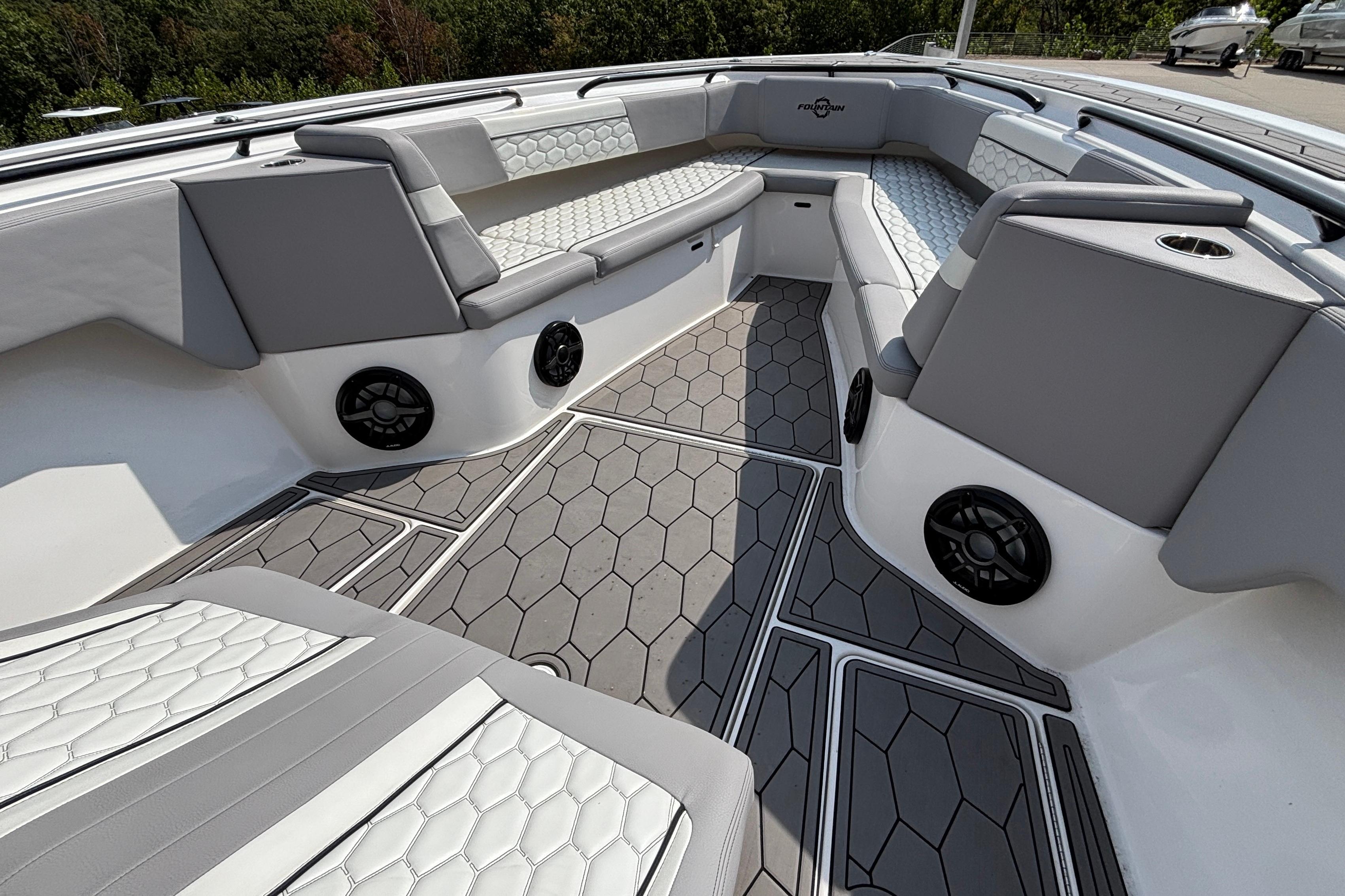 Luxurious interior of 2022 Fountain 38 SC boat with stylish seating and speakers.
