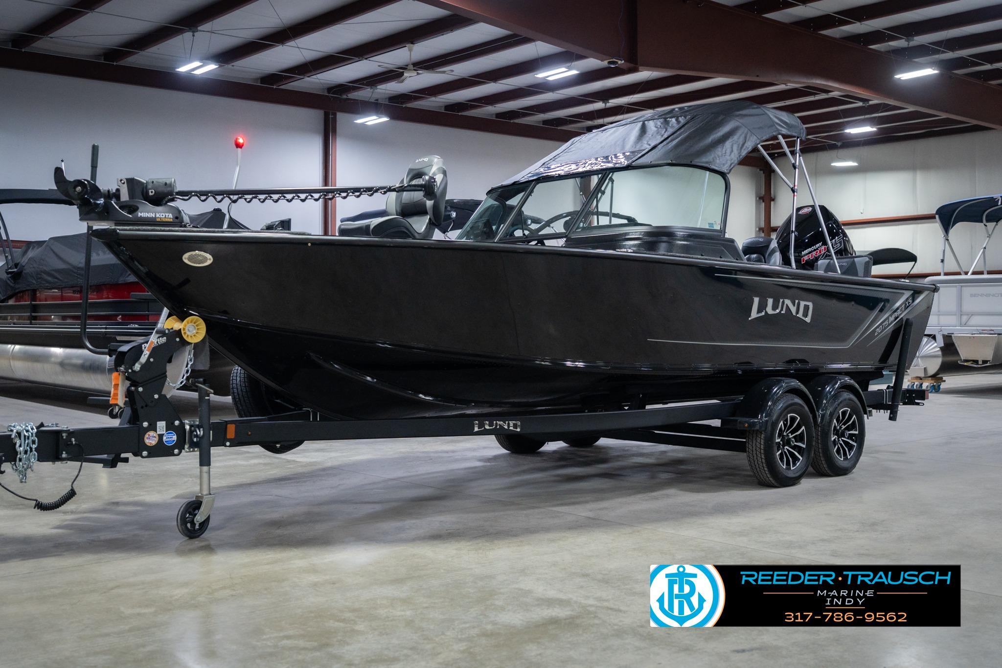 2026 Lund 2075 Impact XS boat in showroom, black exterior, on trailer.