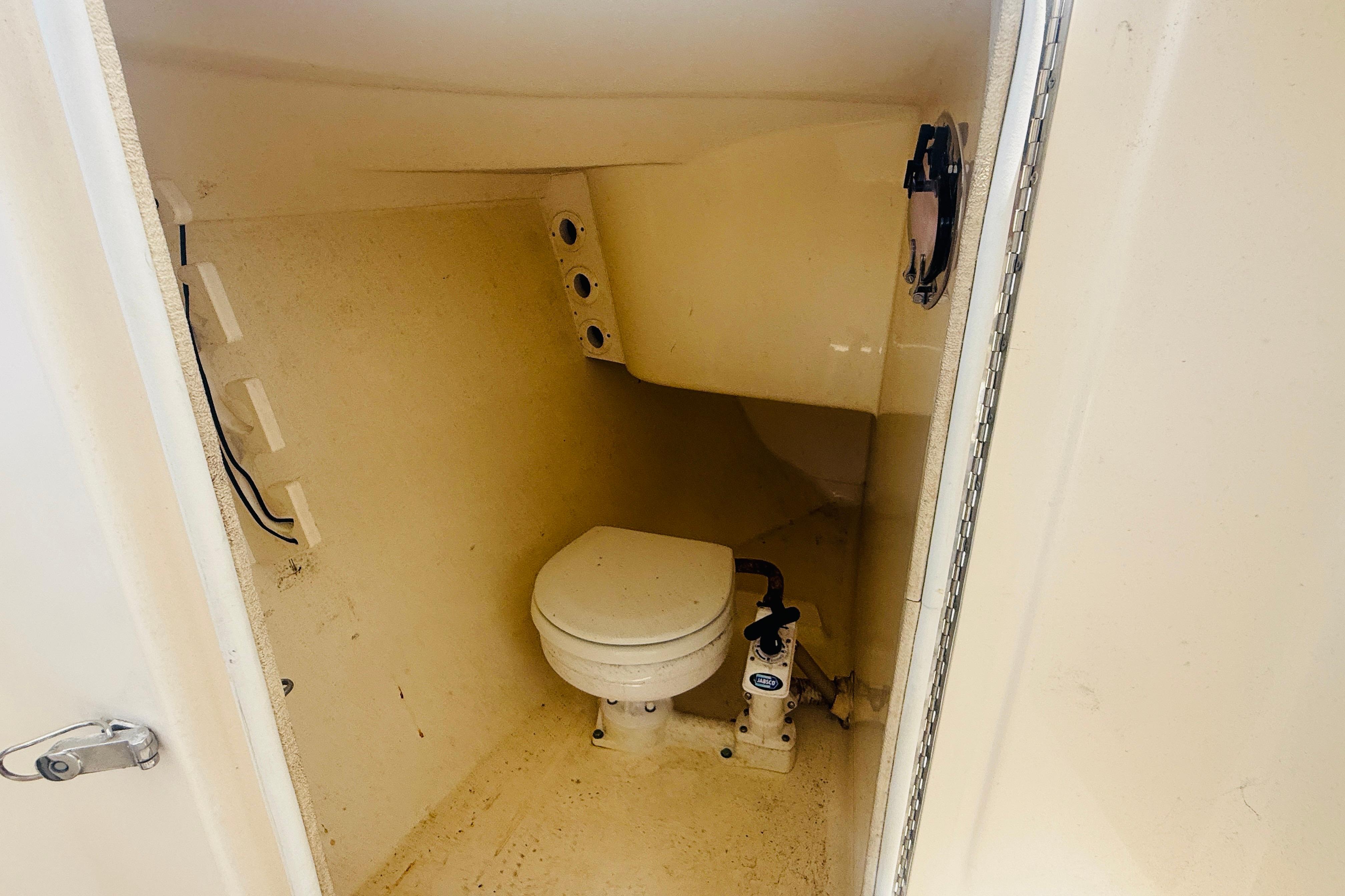 Interior view of a 2012 Scout 245 Dorado boat's compact bathroom with toilet.