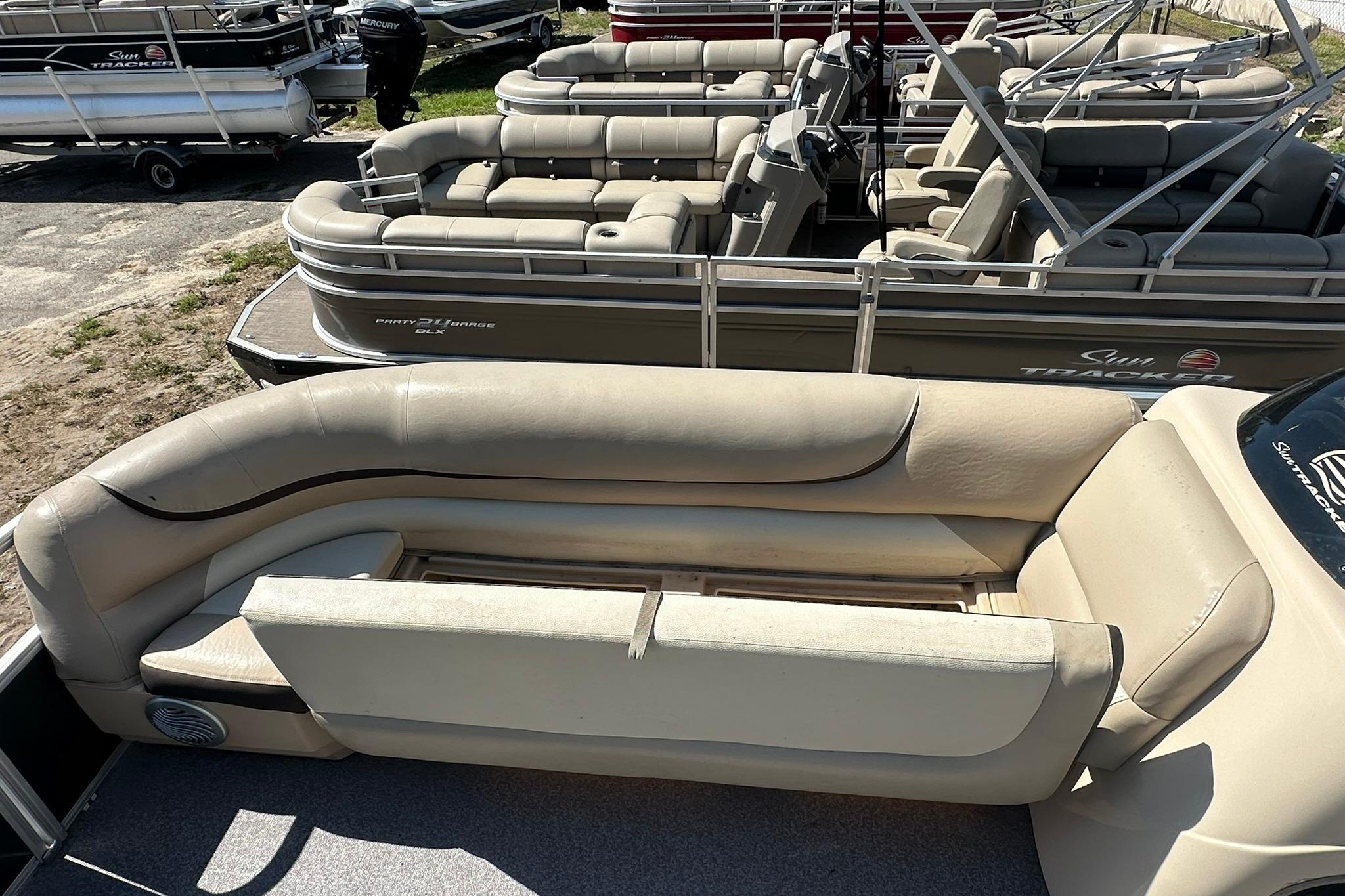 2016 SUNTRACKER Party Barge 20 pontoon boat with beige seating, docked outdoors.