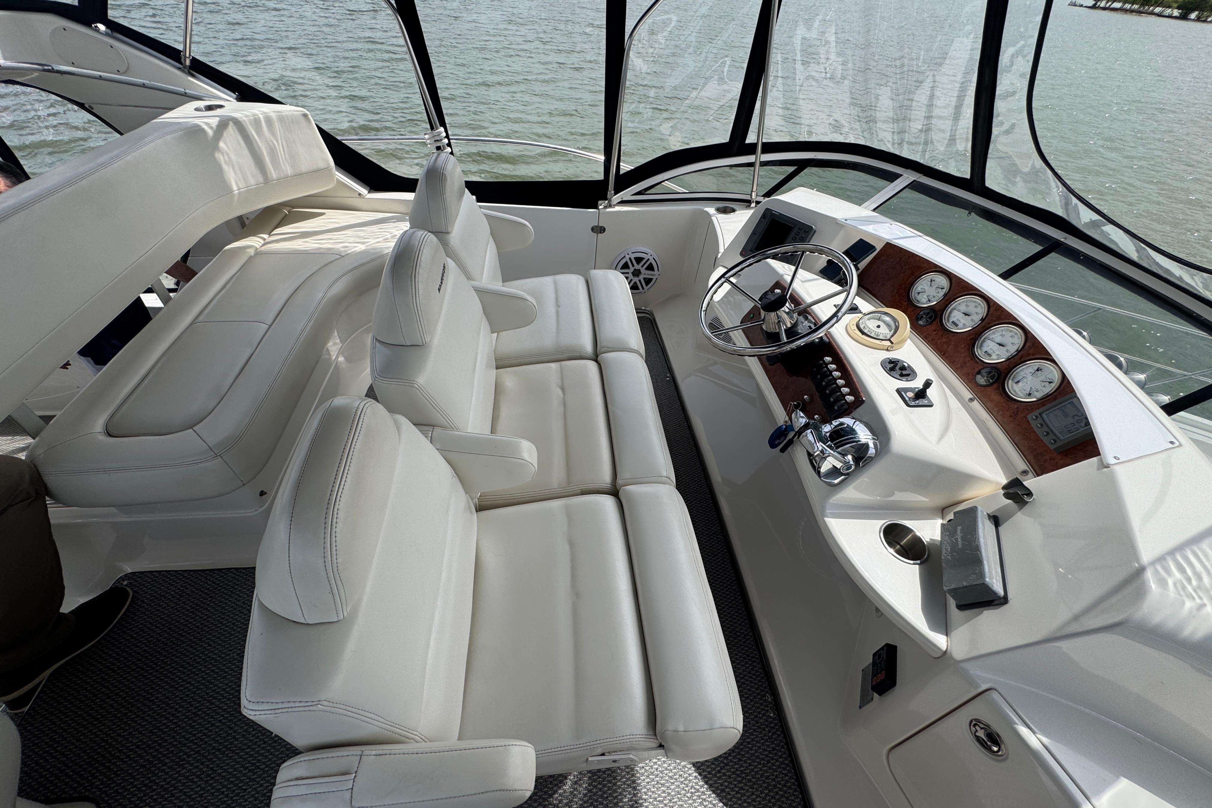 2003 Silverton 39 Motor Yacht helm with white seating and control panel, overlooking water.