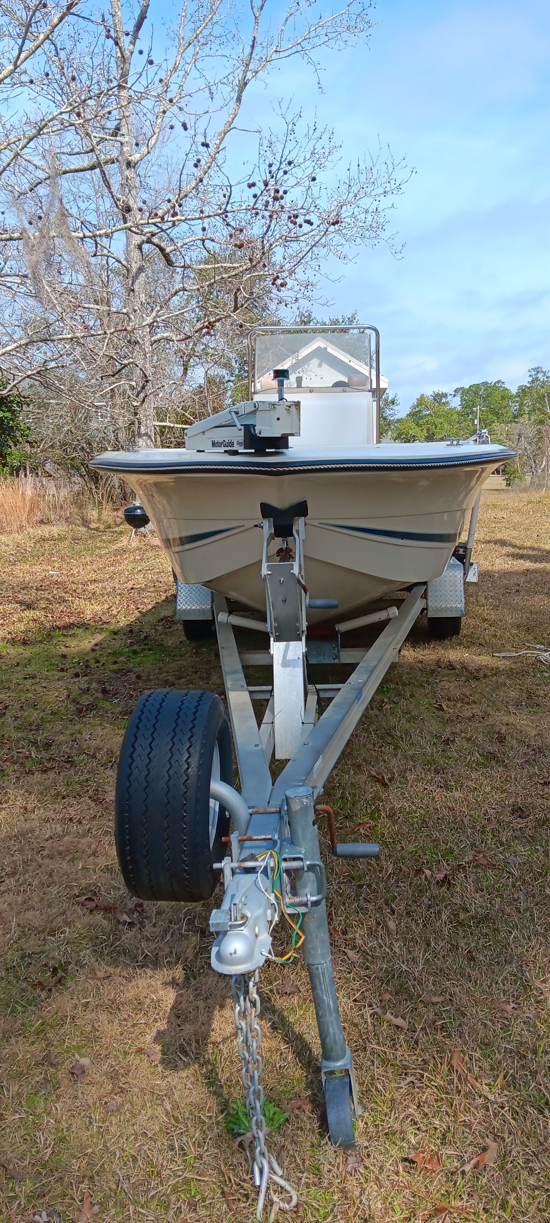 A 1990 Hydra-Sports Vector boat on a trailer, situated on a grassy area.