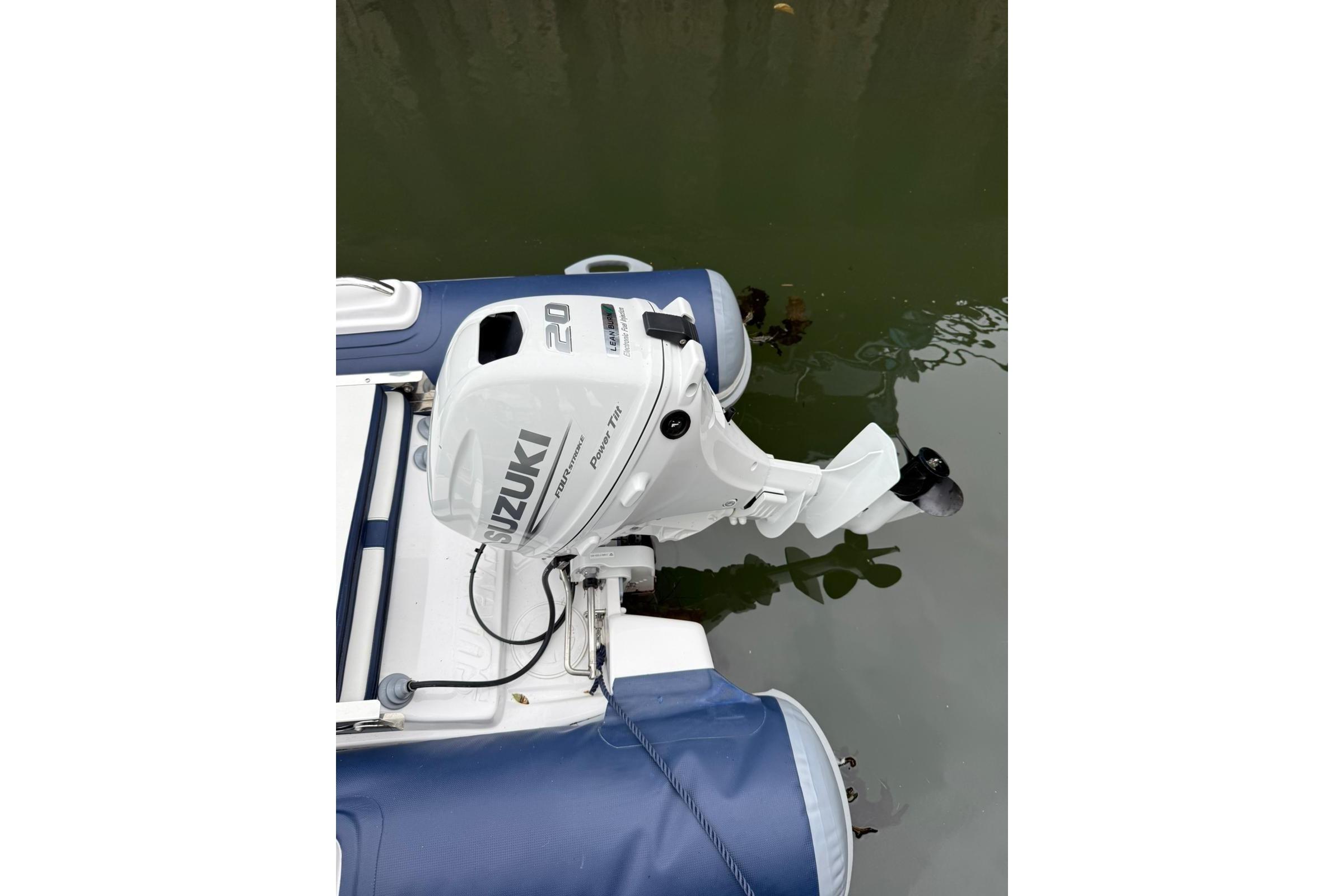2023 Surmarine ST290 inflatable boat with Suzuki 20HP outboard motor on water.