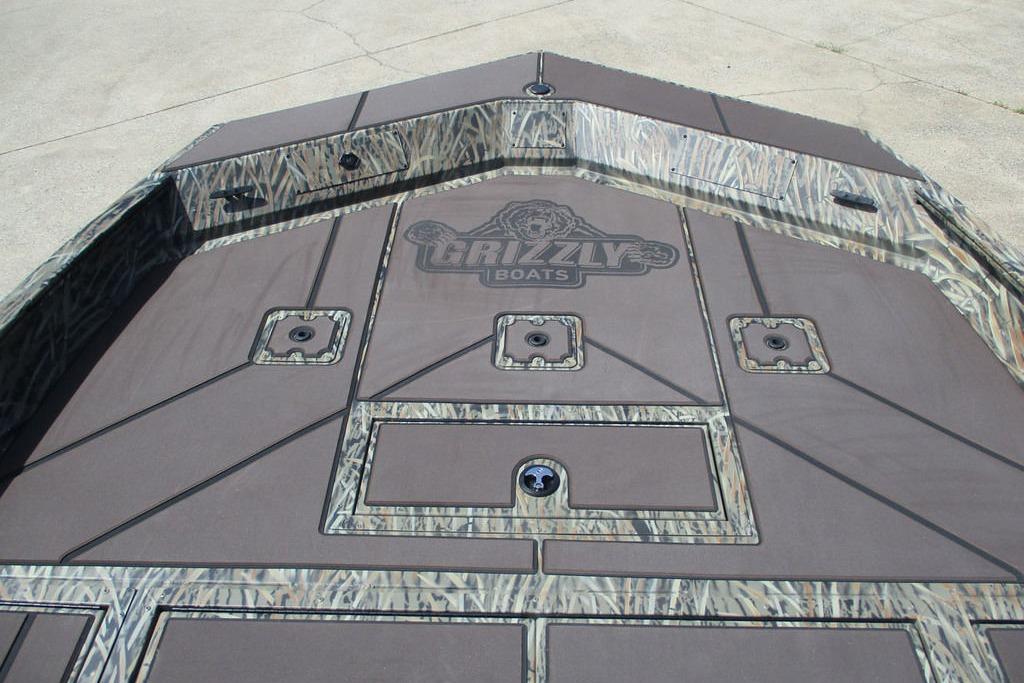 2026 Tracker Grizzly 2072 CC boat deck with camo pattern and storage compartments.