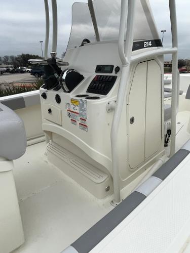 2024 Mako 214 CC center console boat with steering wheel and control panel.