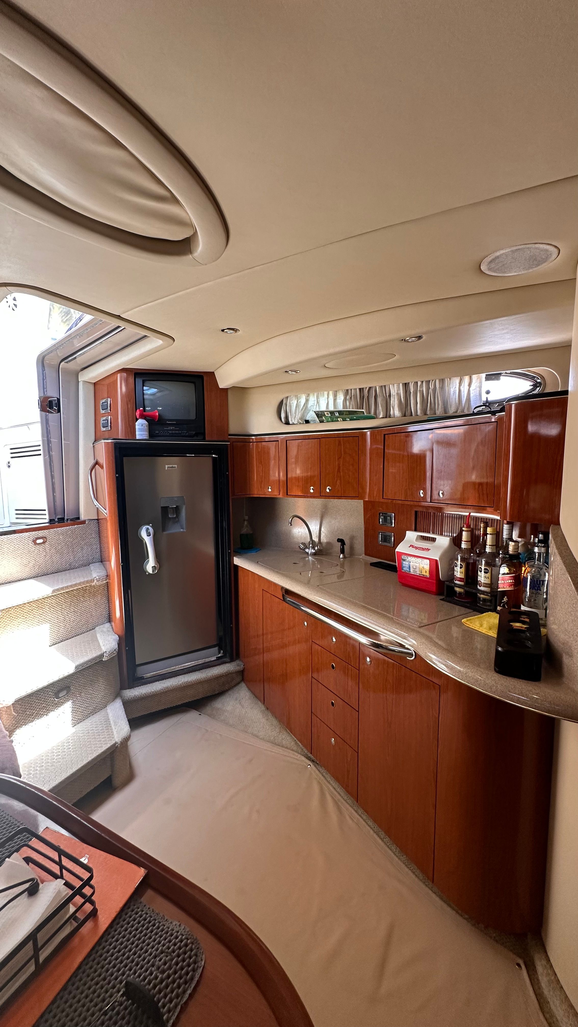 Interior of 2002 Sea Ray 410 Express Cruiser, elegant kitchen with wooden cabinets.