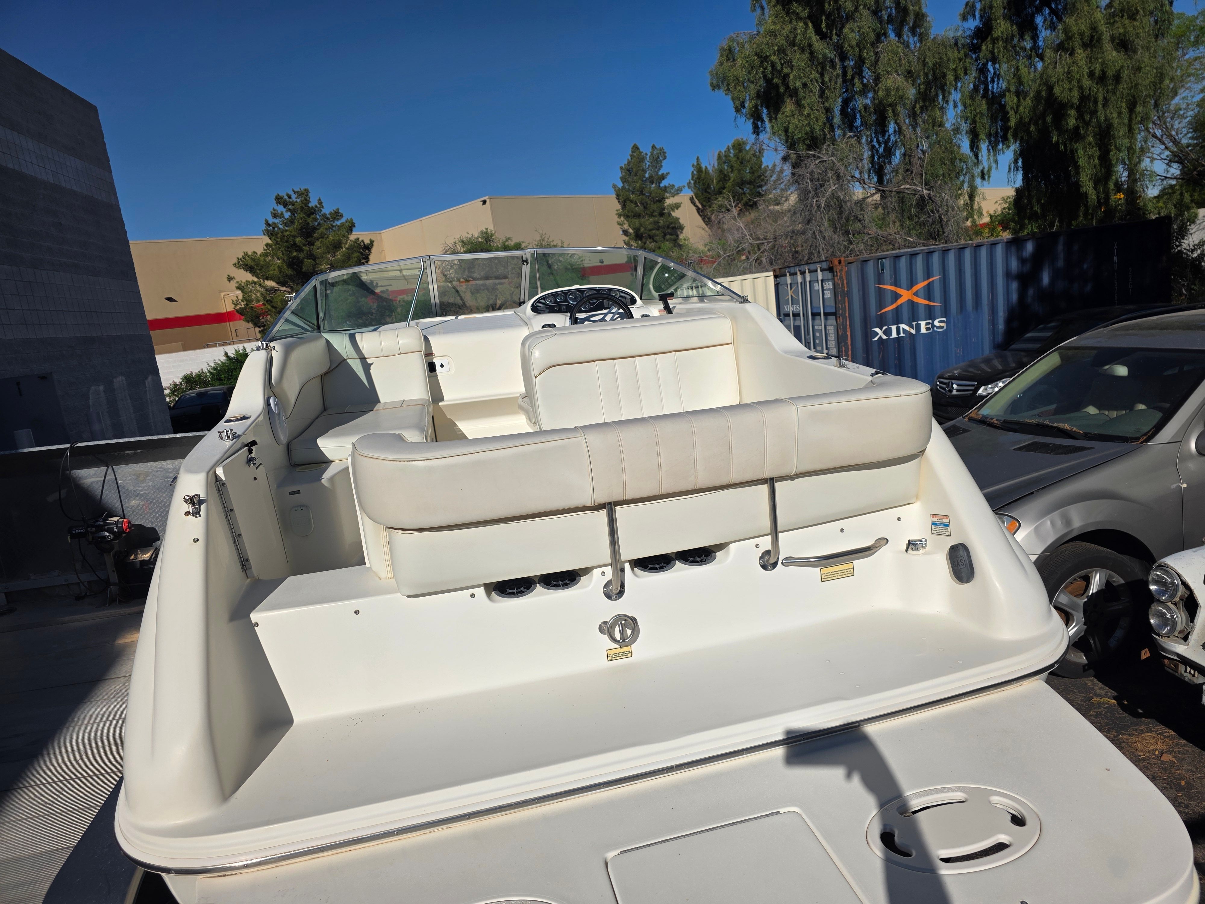 A 1997 Sea Ray 240 Sundeck is parked, featuring white seating and a spacious deck.