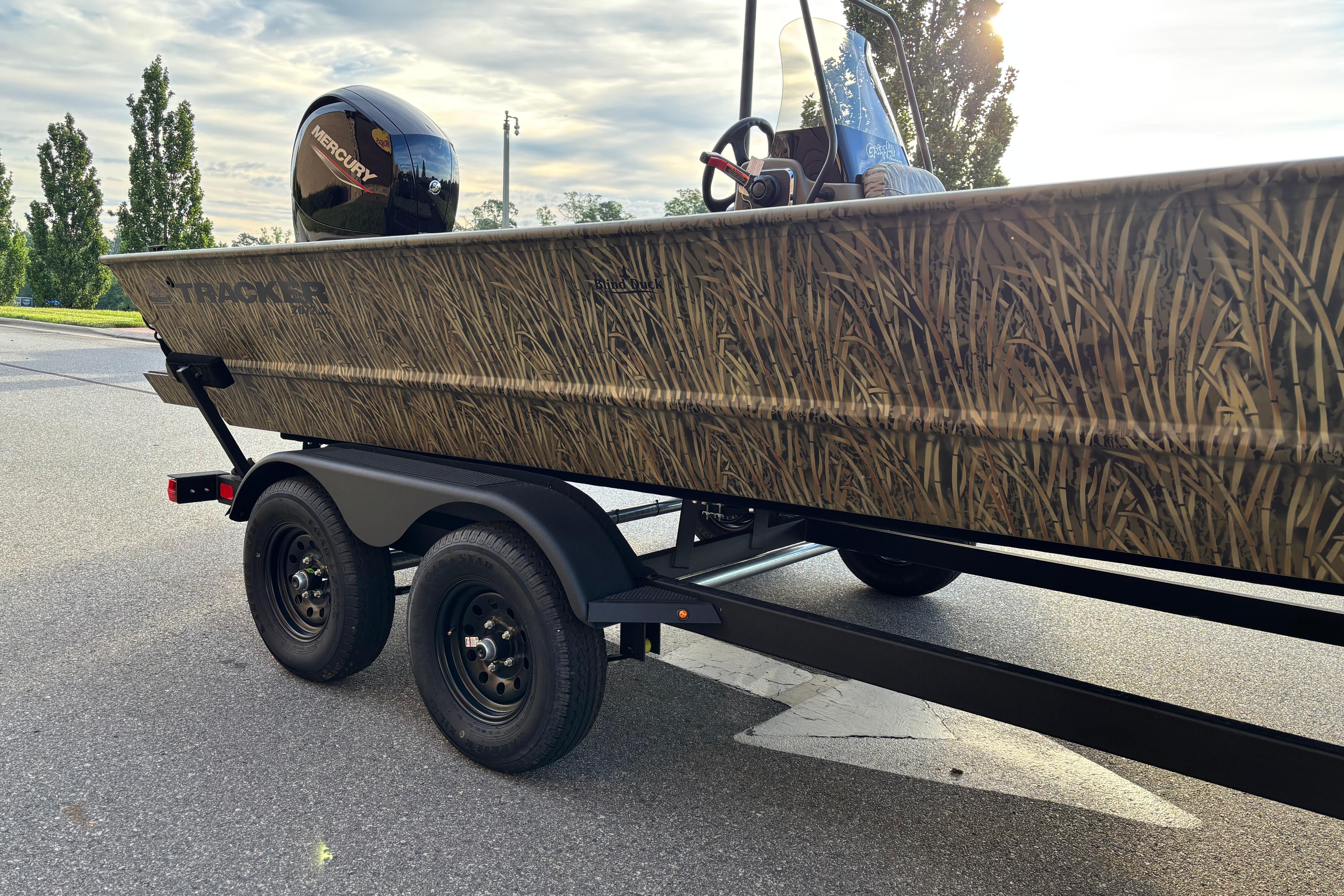 2026 Tracker Grizzly 2072 CC boat with camouflage design on a trailer.