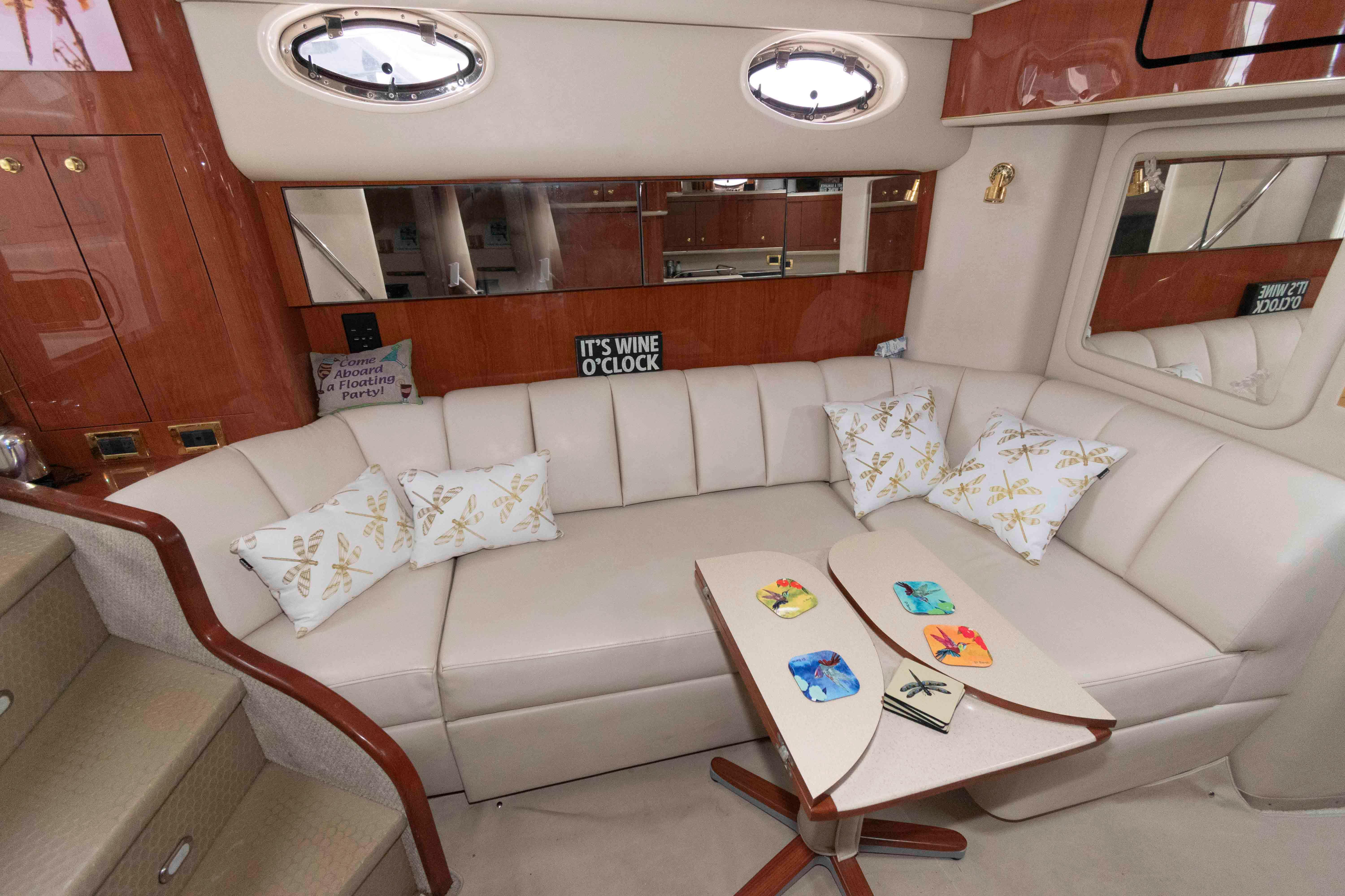 Luxurious interior of 1998 Sea Ray 450 Sundancer yacht with plush seating and decorative pillows.