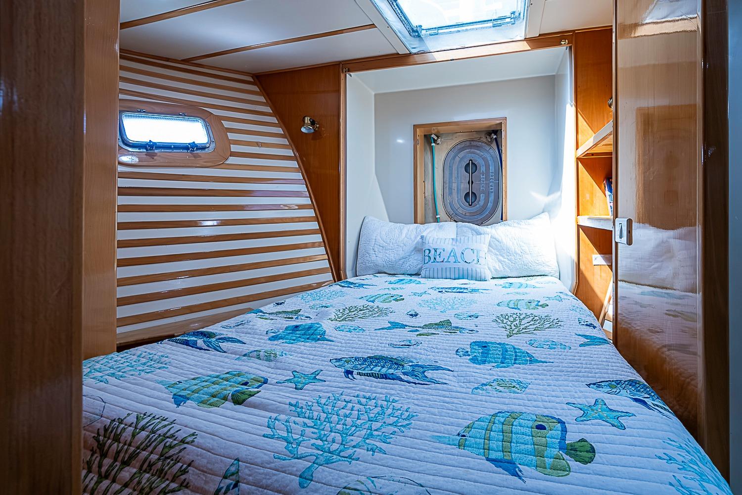 Cozy cabin interior of 2003 Magna Marine Nova Scotia 47 with nautical-themed bedding.