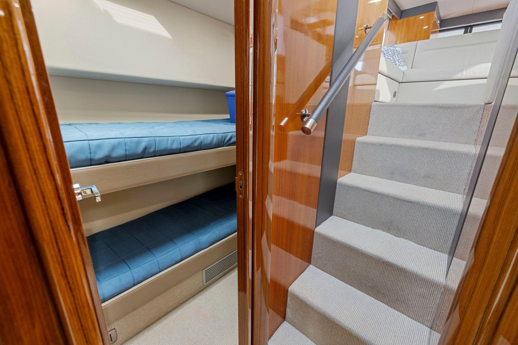 Interior of 2014 Maritimo M50 yacht featuring bunk beds and carpeted stairs.