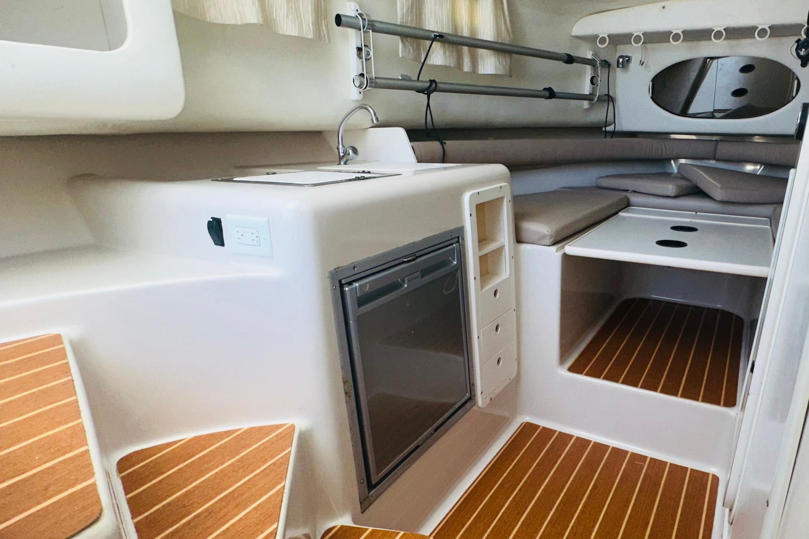 1994 Pro-Line 2950 Walkaround cabin interior with kitchenette and seating area.
