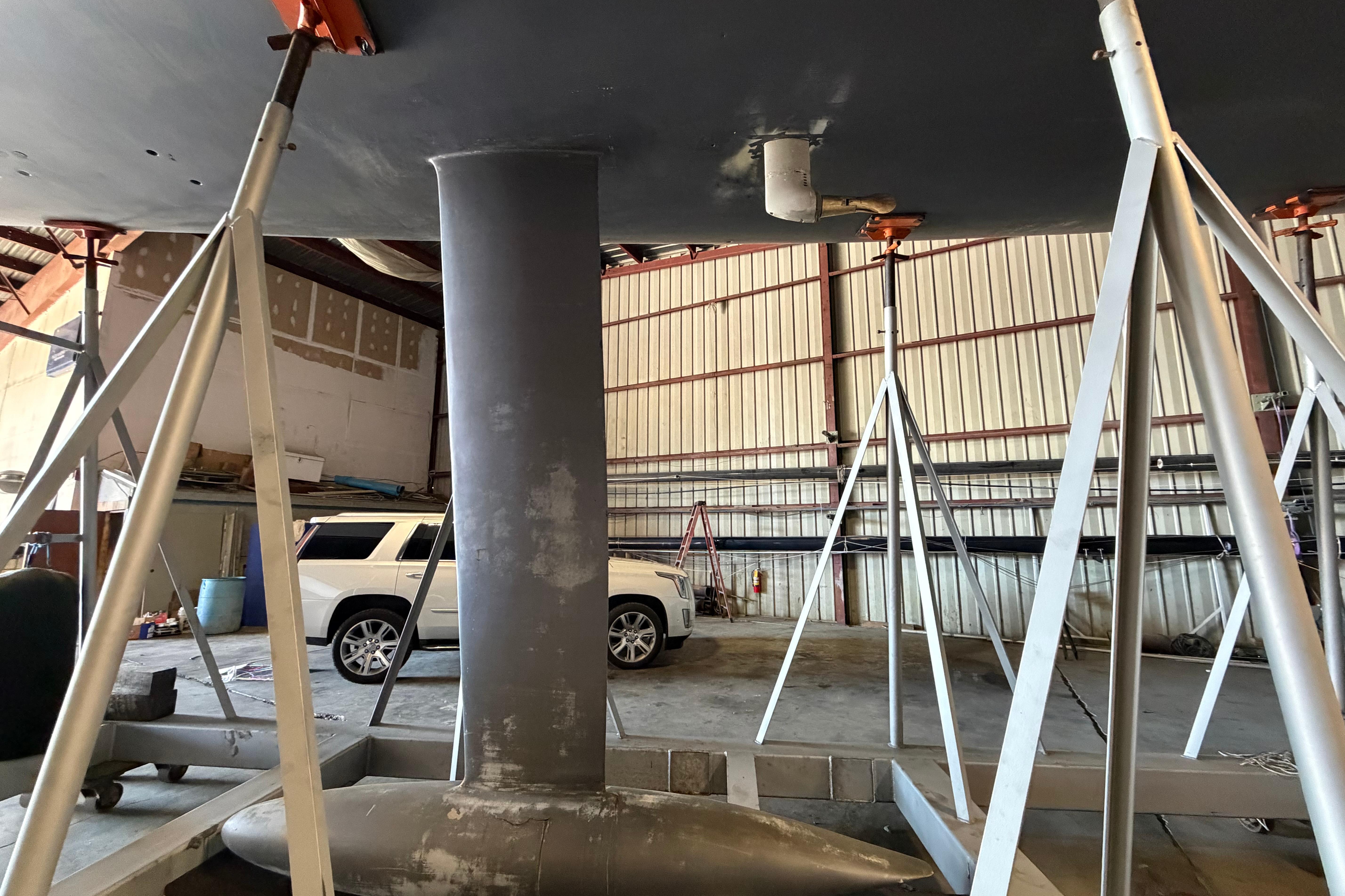 Andrews 63 sailboat keel in a workshop with support stands and a white SUV.