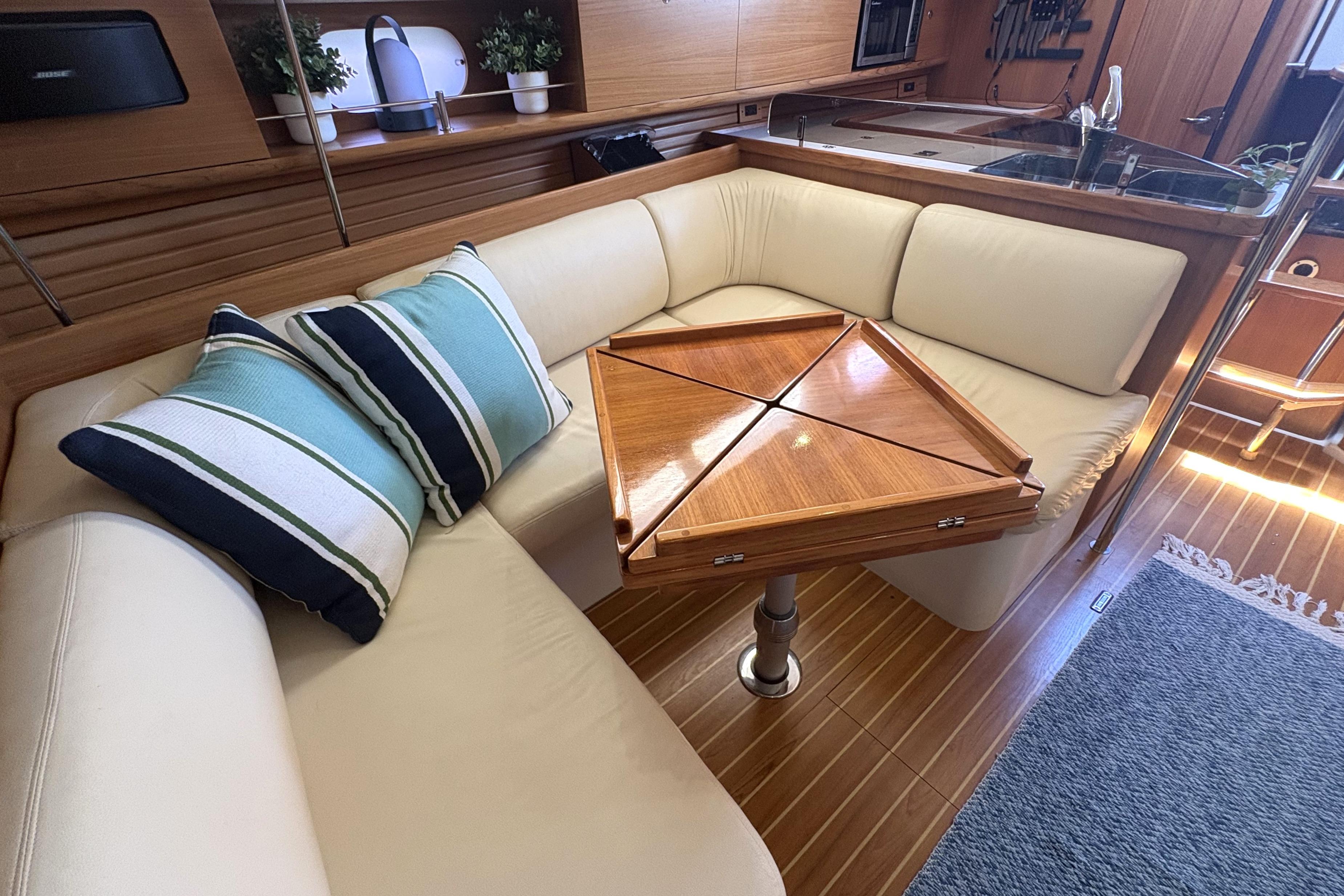 Interior of 2011 Catalina 355 yacht with cozy seating and wooden table.