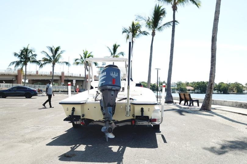 2002 Key West 1760 Stealth boat with Yamaha motor, parked near palm trees.