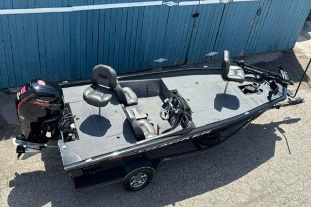 2023 Tracker Pro Team 190 TX Tournament Edition fishing boat, aerial view, parked by blue wall.
