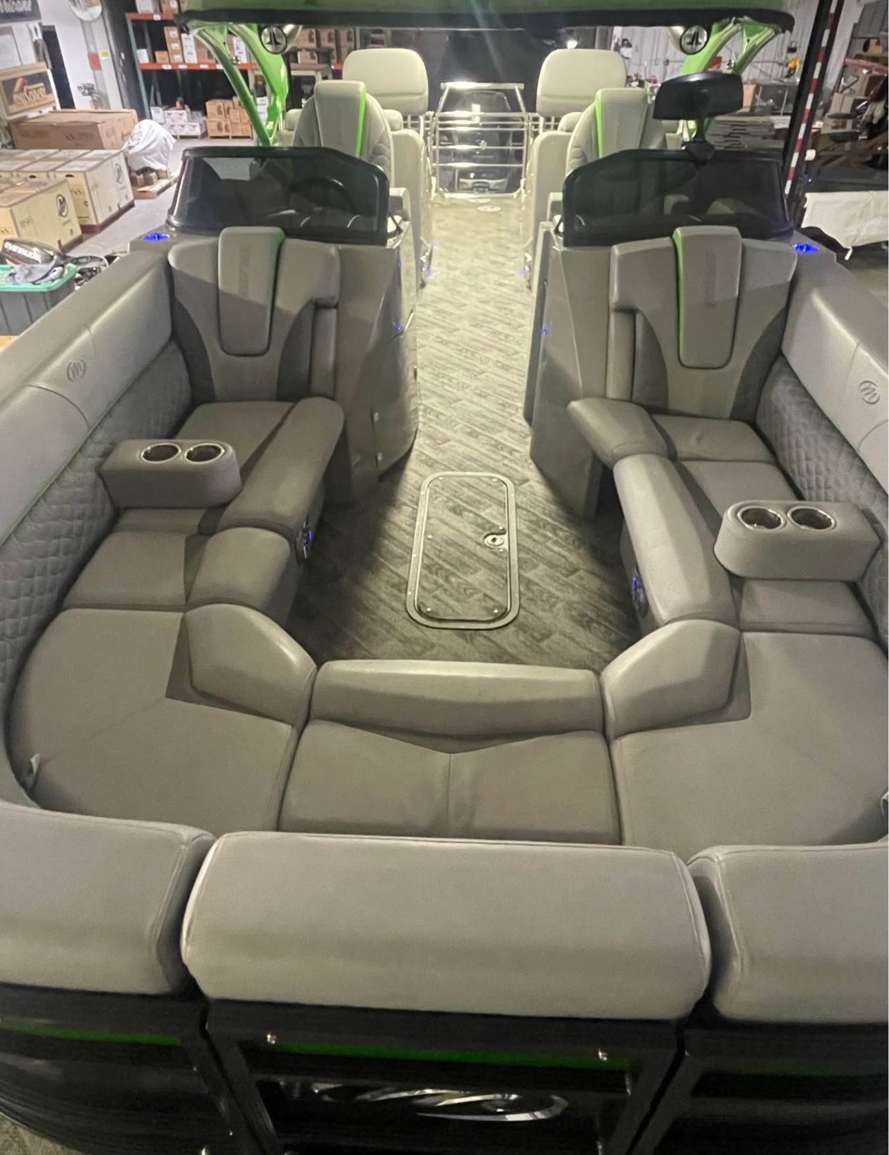 Interior of a luxury pontoon boat with gray seating and cup holders.