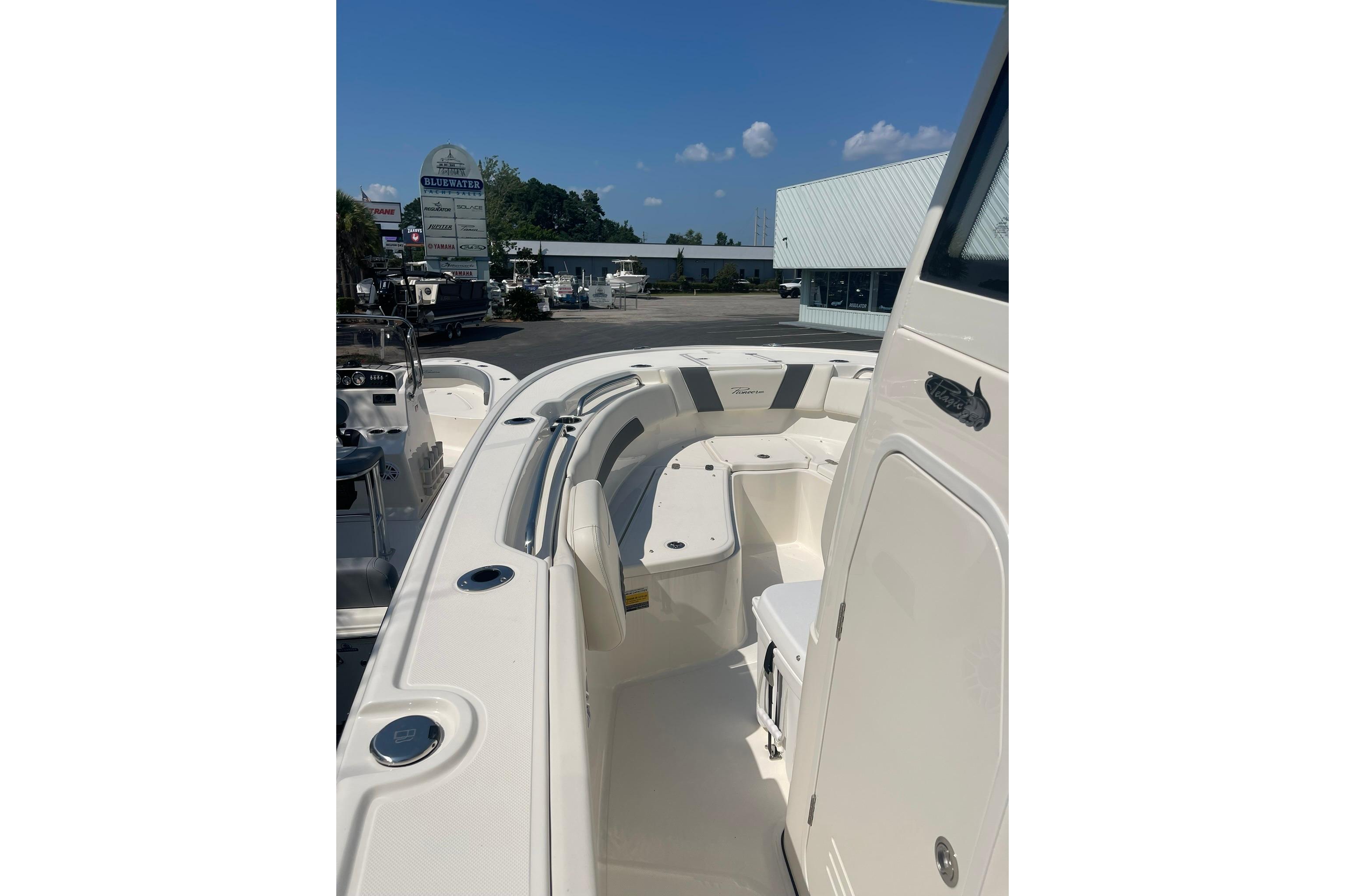 2026 Pioneer 250 Pelagic boat interior with seating, docked at a marina under clear skies.