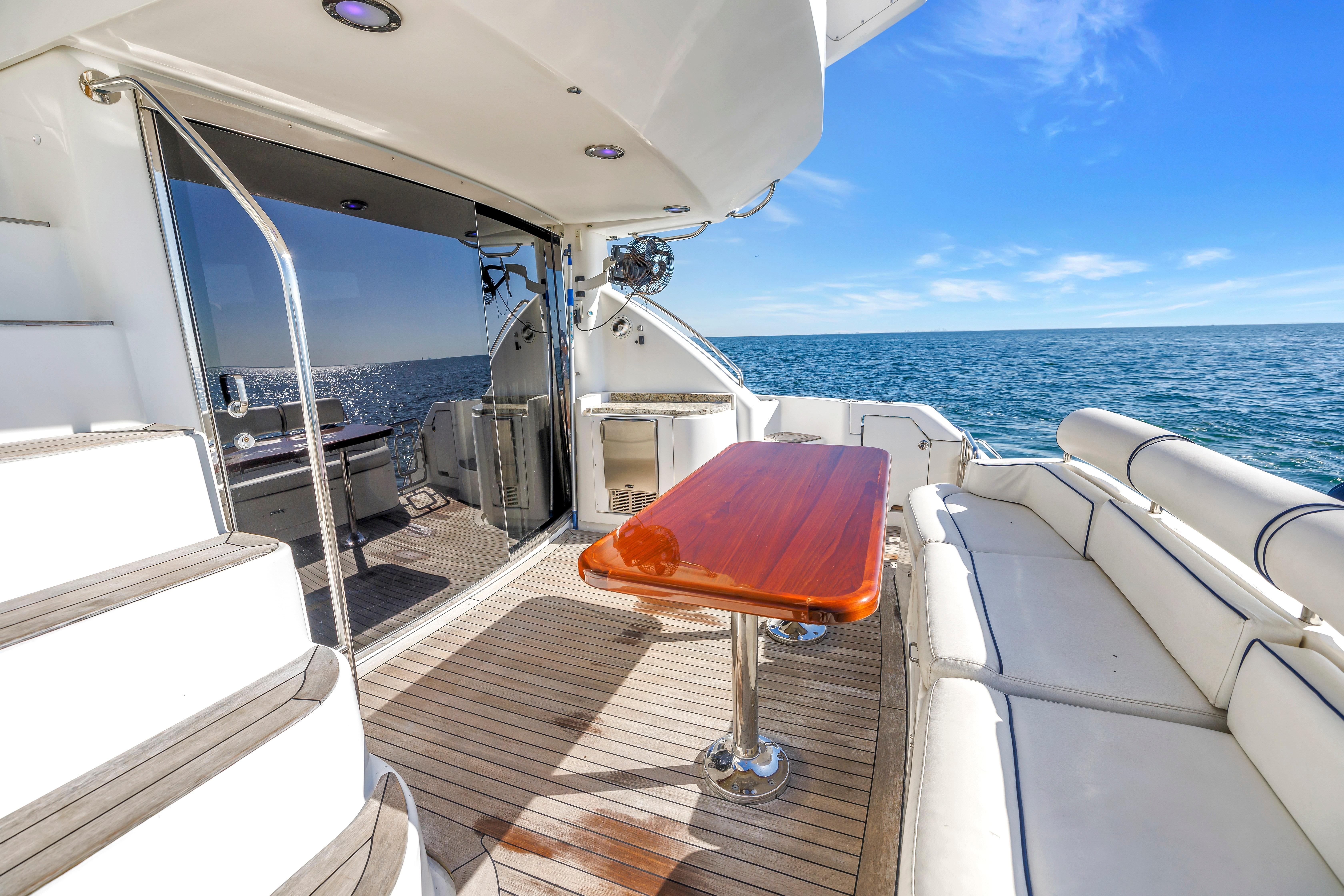 Luxurious 2001 Neptunus 56 Flybridge yacht deck with ocean view and elegant seating.