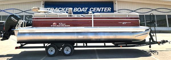2024 Sun Tracker Party Barge 24 DLX pontoon boat on trailer at dealership.