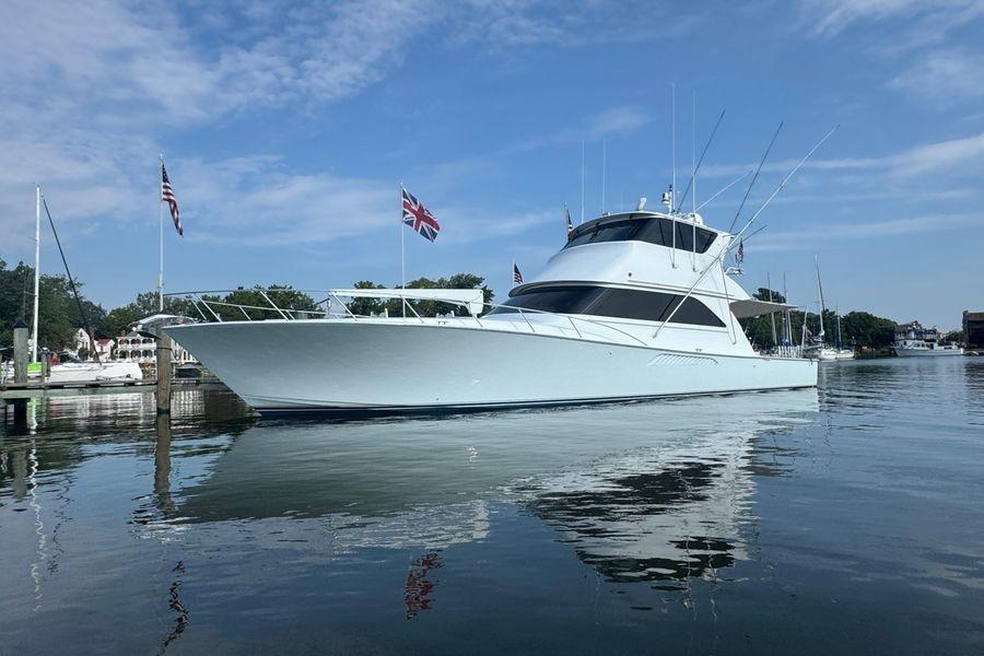 2002 Viking 61 Enclosed Bridge yacht docked on calm water under blue sky.