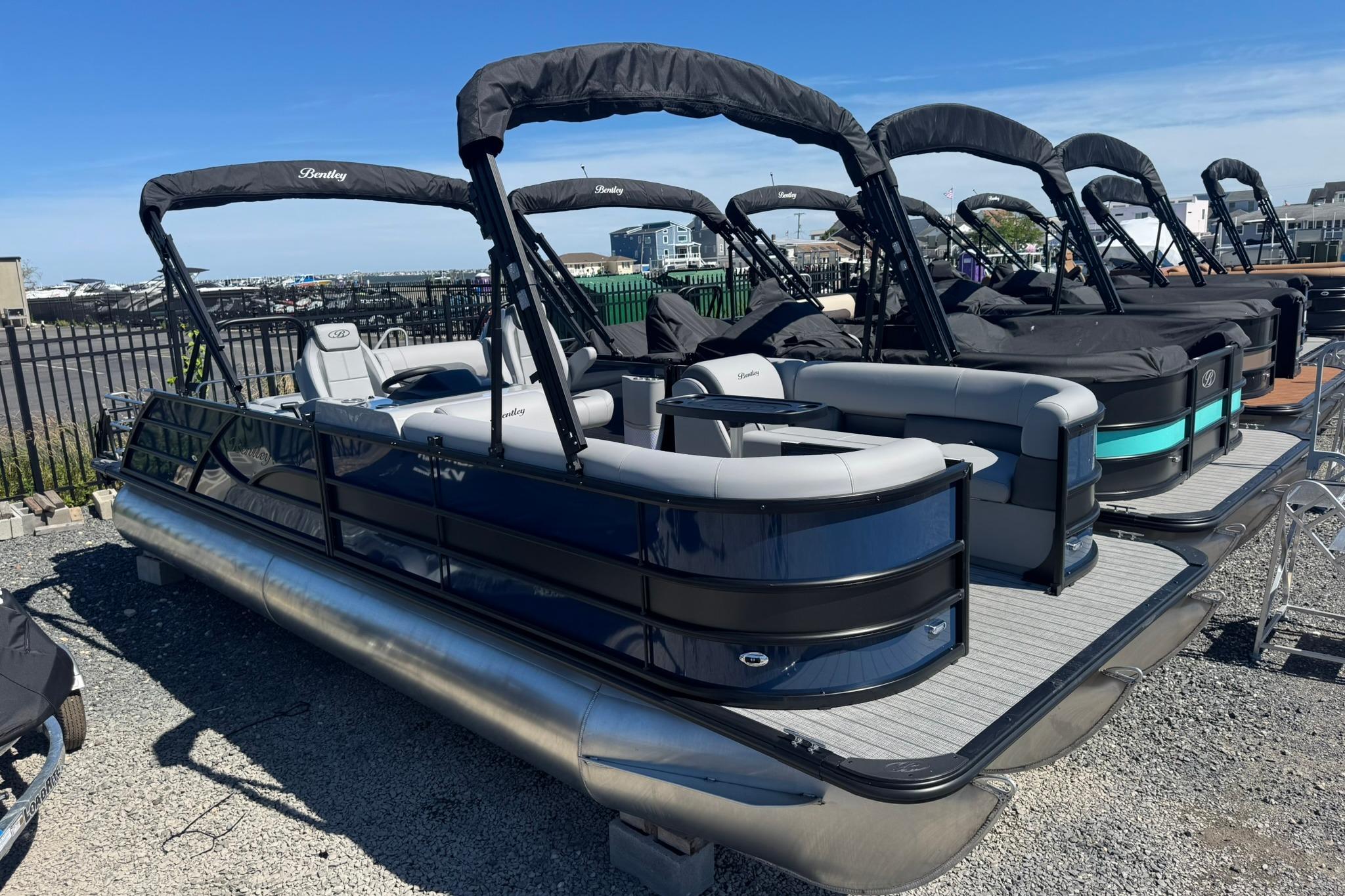 2026 Bentley Pontoons Legacy 243 Swingback boats displayed in a row at a marina.
