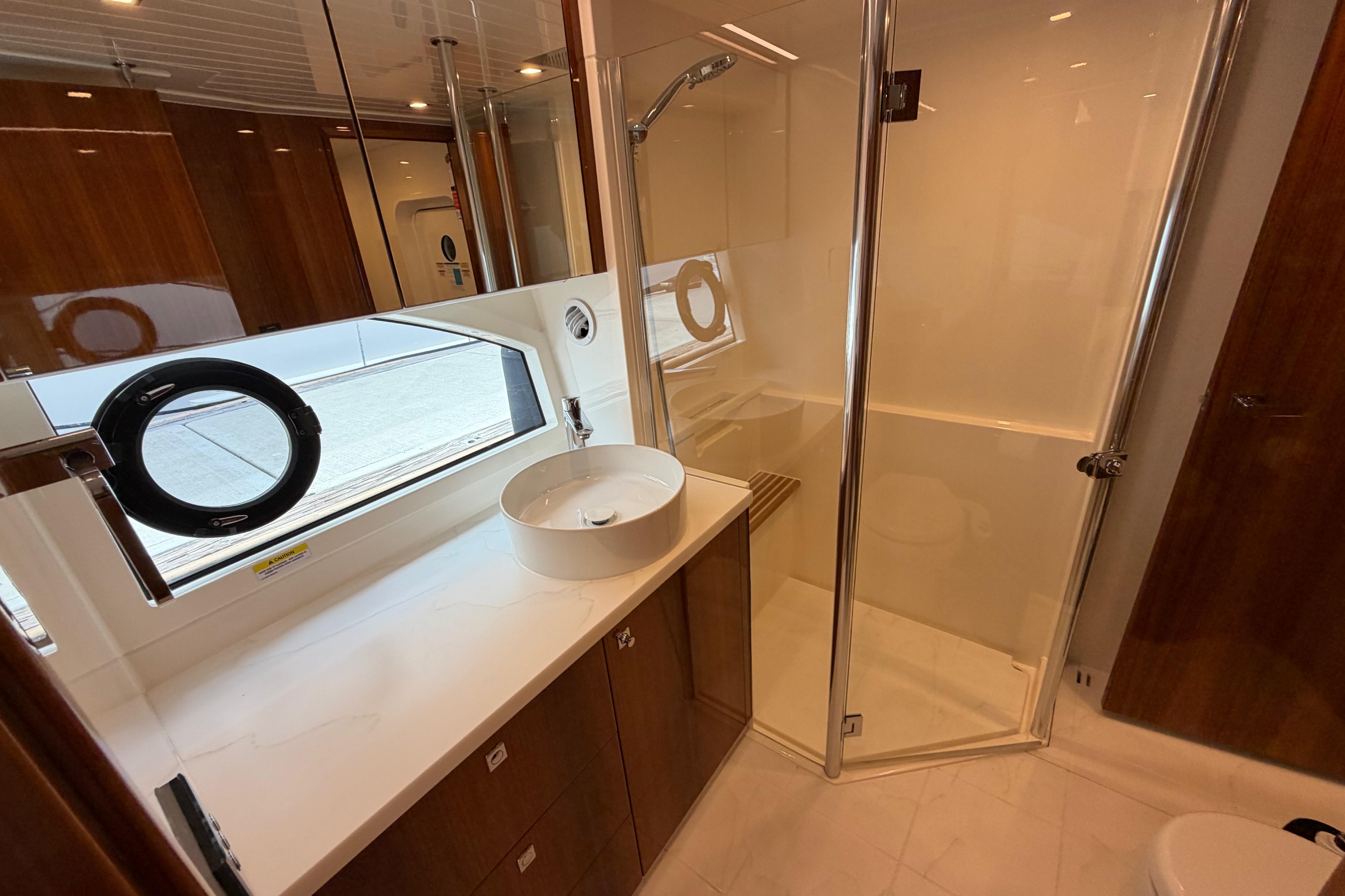 Luxurious bathroom in 2023 Riviera 645 SUV yacht with modern fixtures and elegant design.