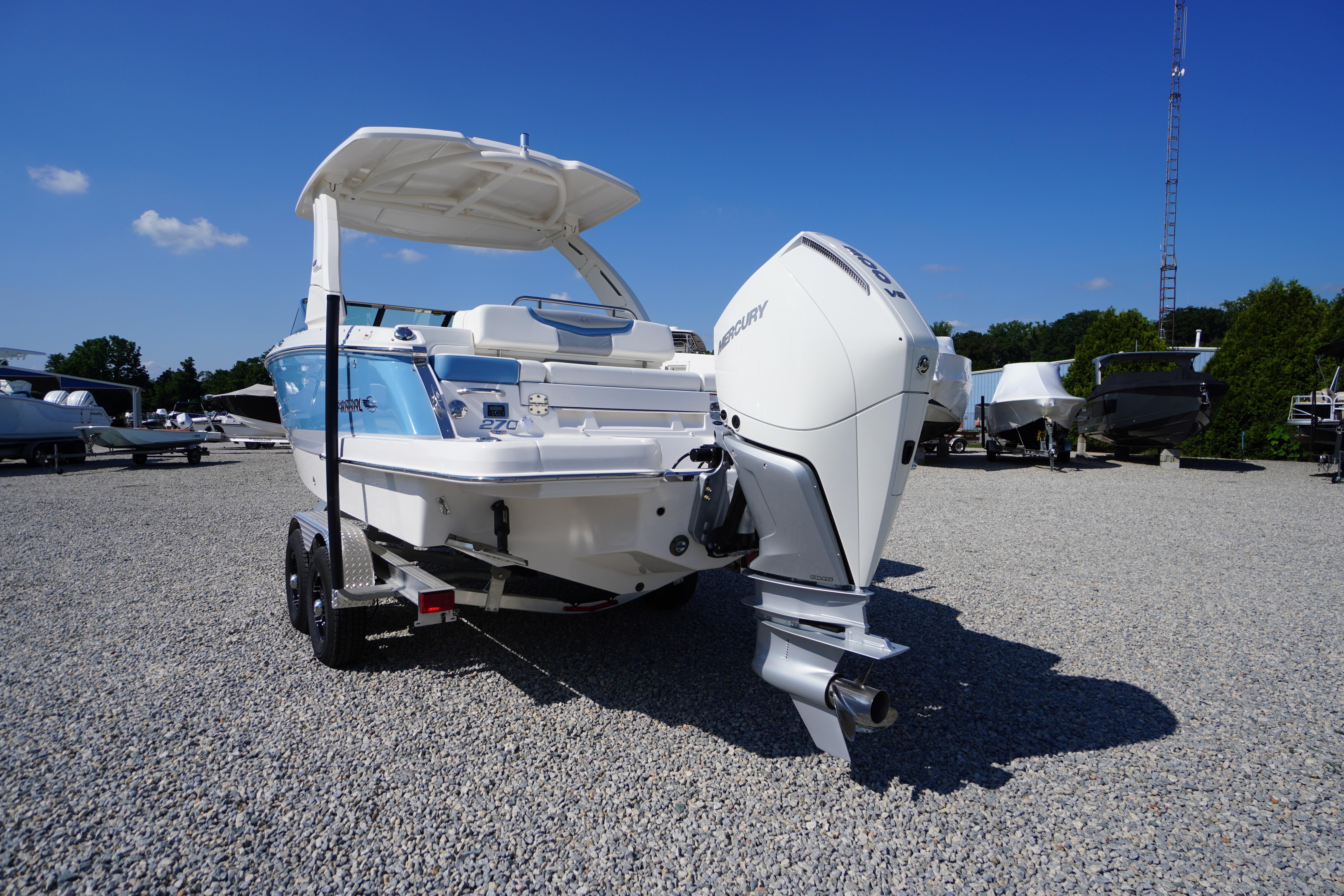 2026 Chaparral 270 OSX boat with Mercury outboard engine on gravel lot.