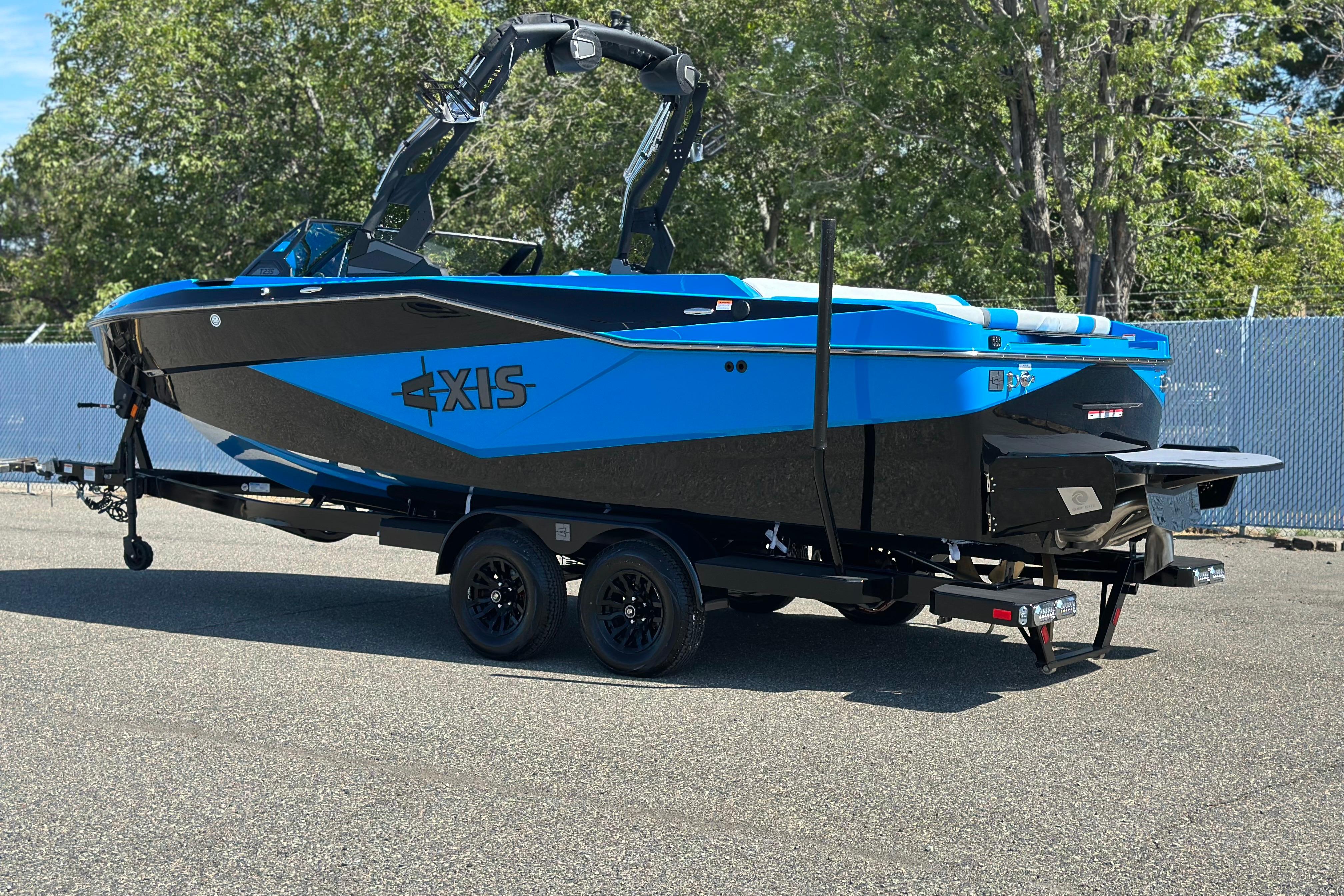 2026 Axis T235 boat in vibrant blue on a trailer, parked outdoors.