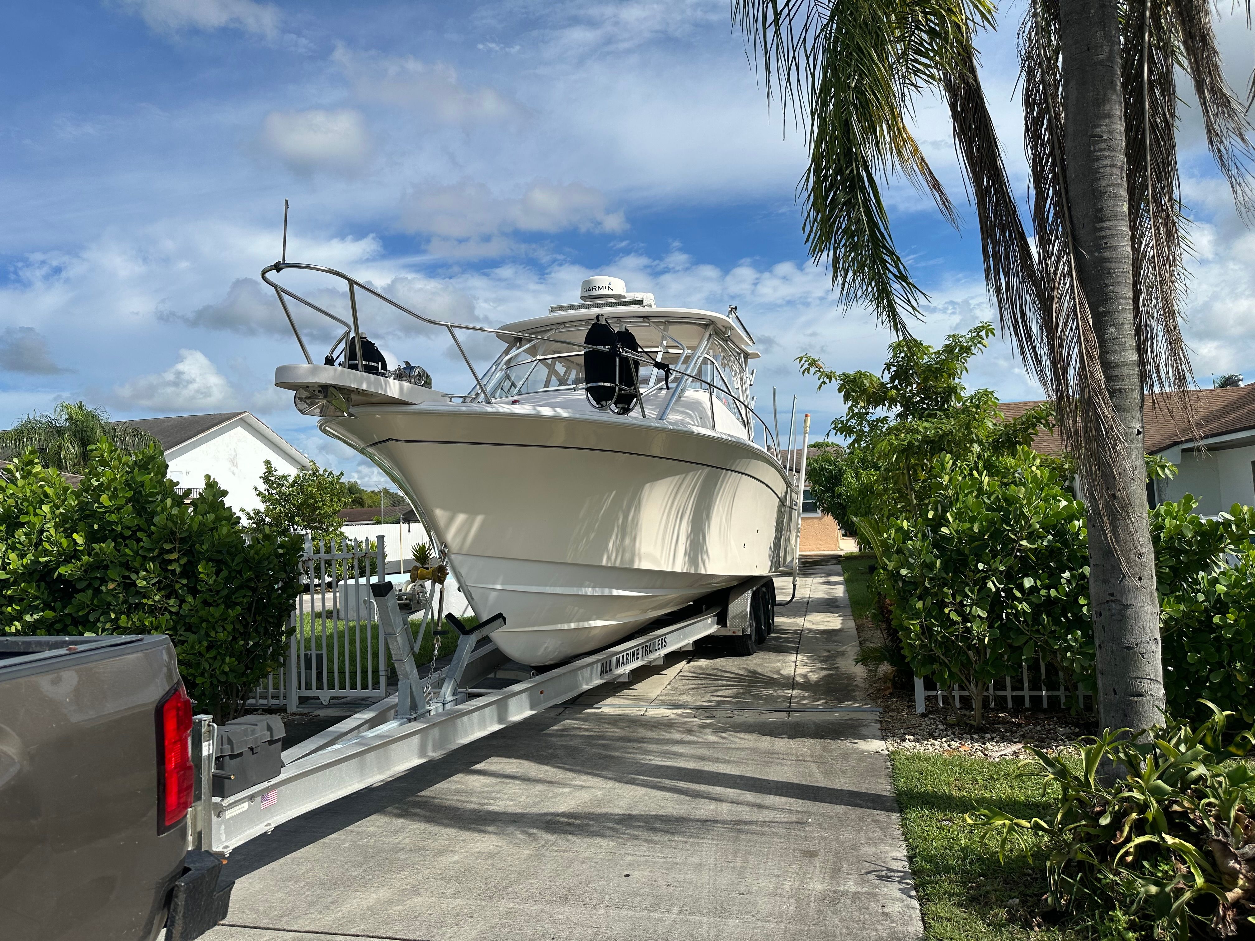 A 2003 Grady-White Express 330 boat on a trailer in a driveway.