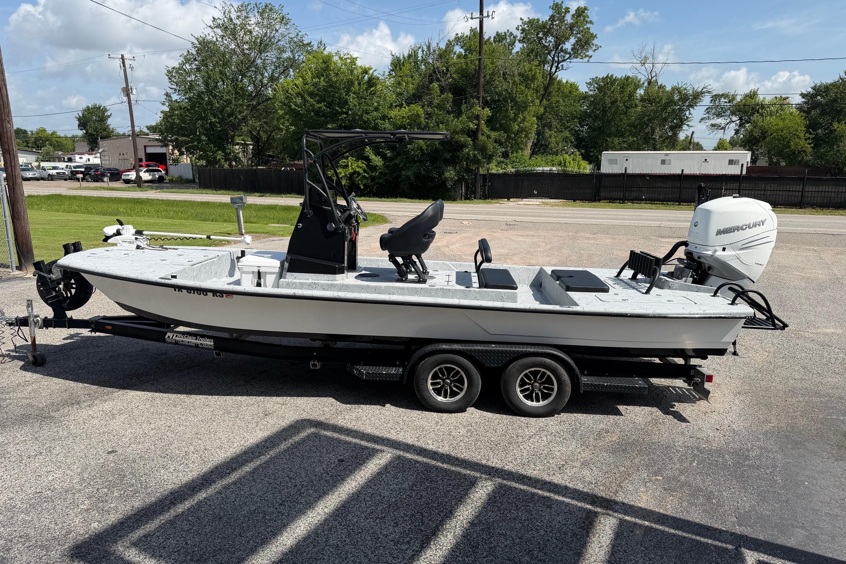 2023 Haynie 23 Super Cat boat on trailer, parked outdoors, featuring a Mercury outboard motor.