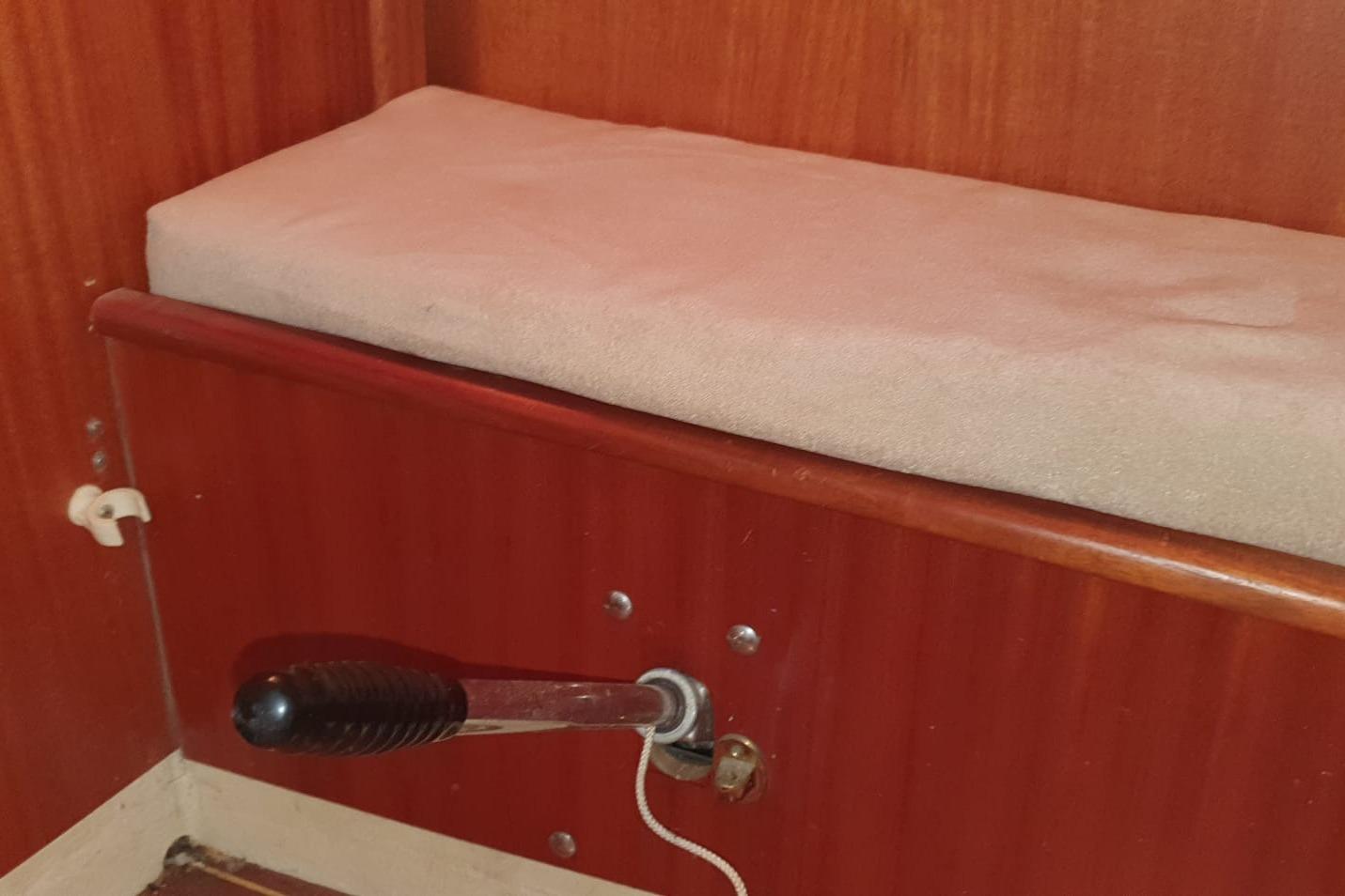 Interior of 1989 X-Yachts X-119 with wooden paneling and cushioned seat.