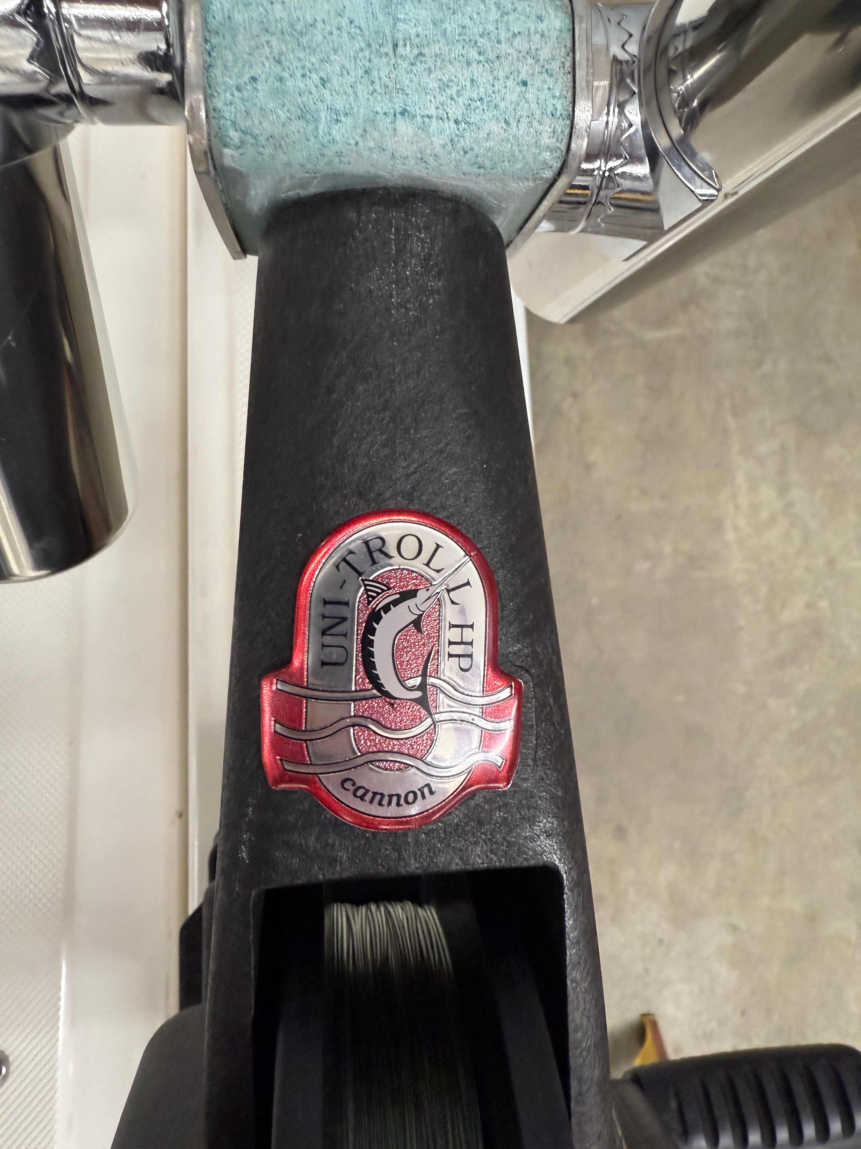 Cannon Uni-Troll HP sticker on fishing reel, close-up.