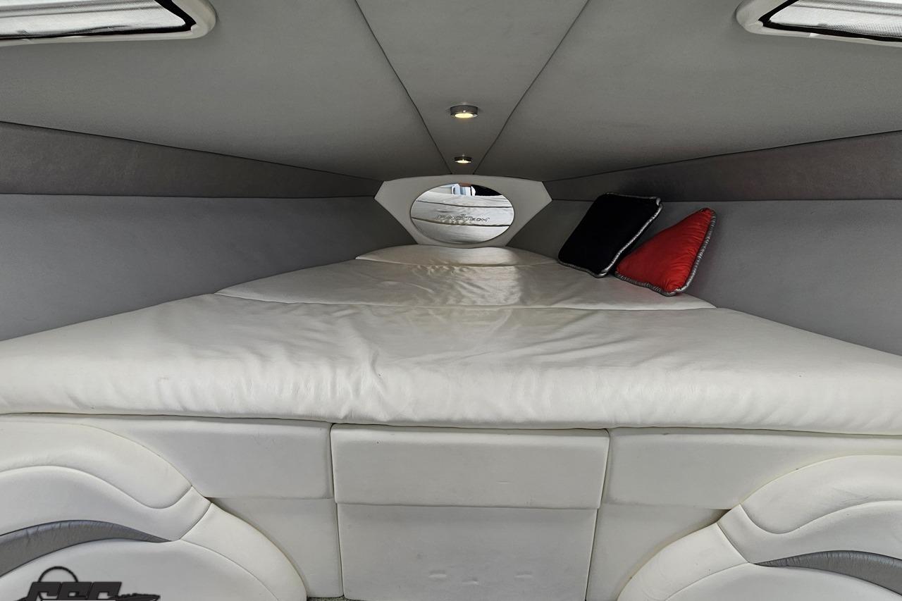 Interior cabin of 2005 Formula 271 FASTech boat with cozy bedding and cushions.