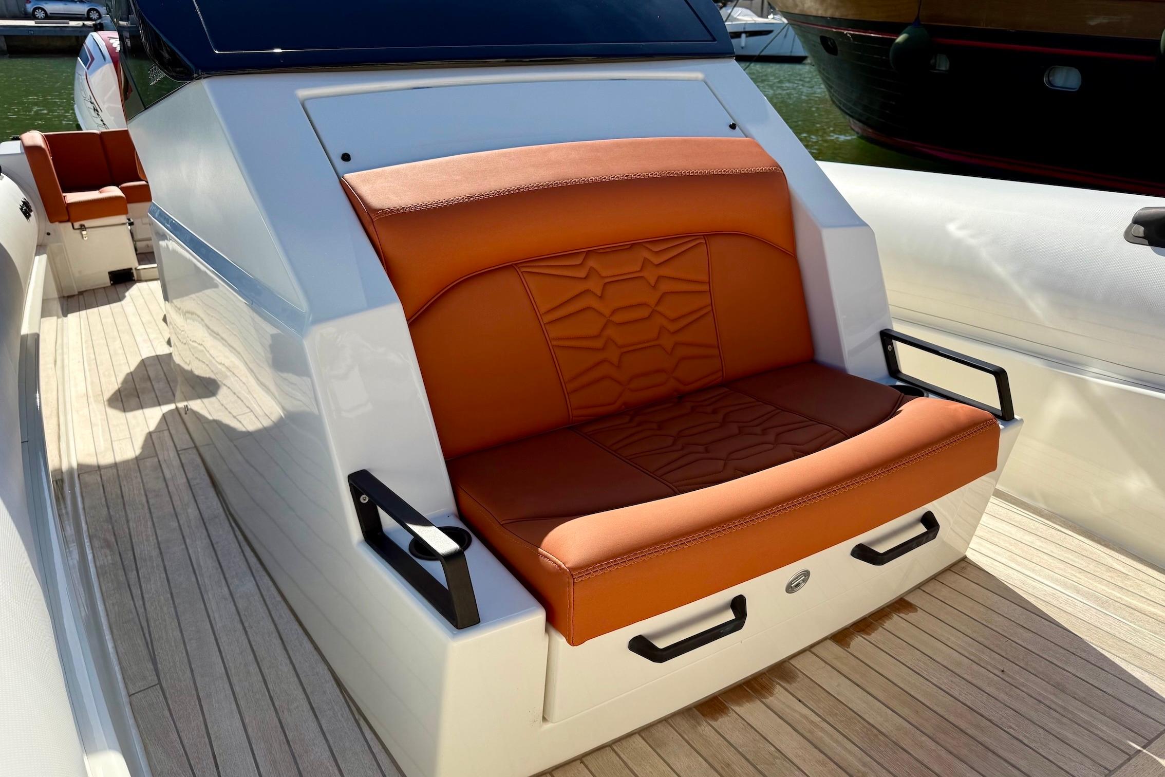 Luxury seating on 2025 Technohull 38 Grand Sport boat with orange upholstery.