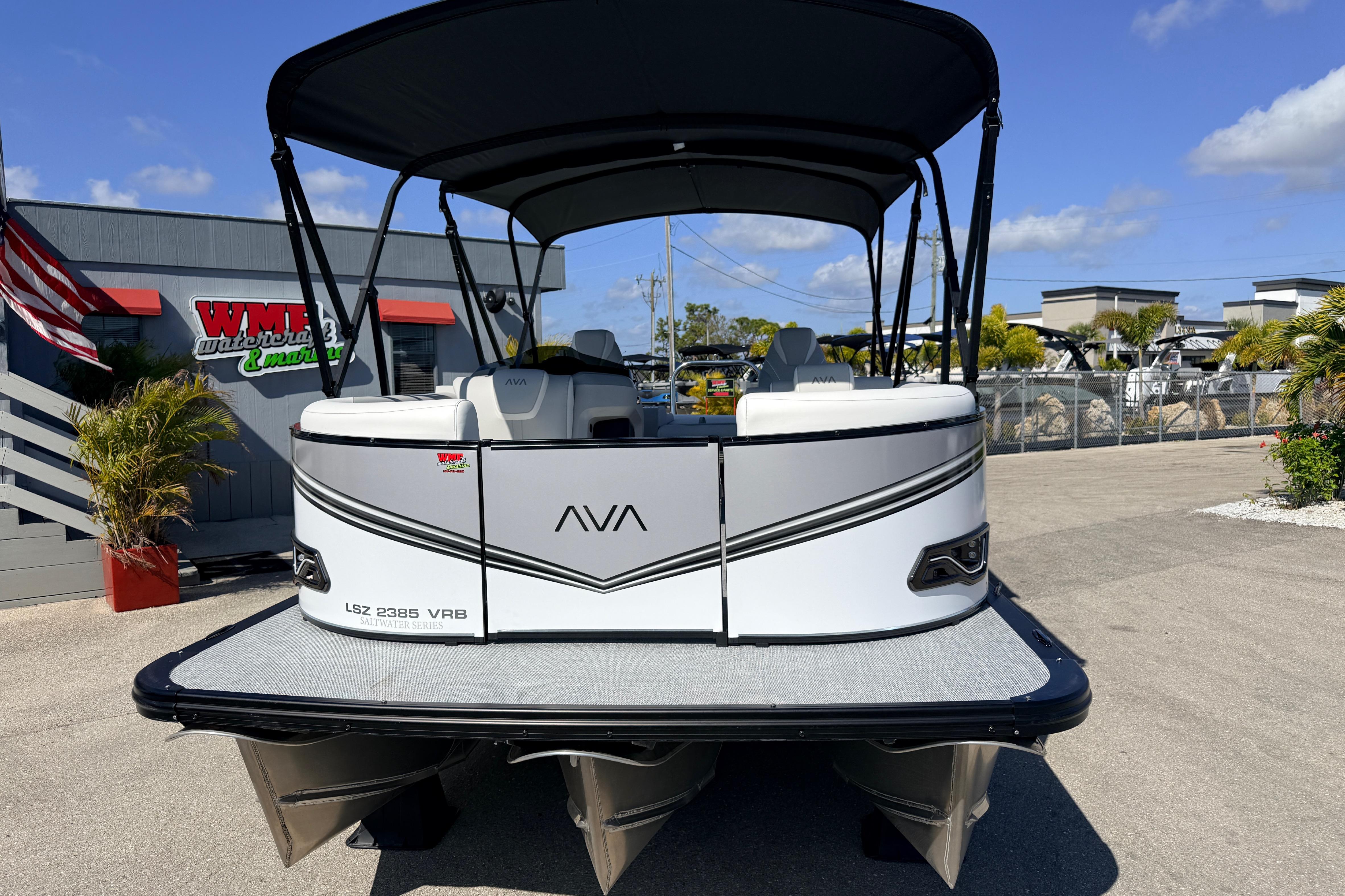 2026 Avalon 2385 LSZ Versatile Rear Bench Tri Toon boat at marina, sunny day.