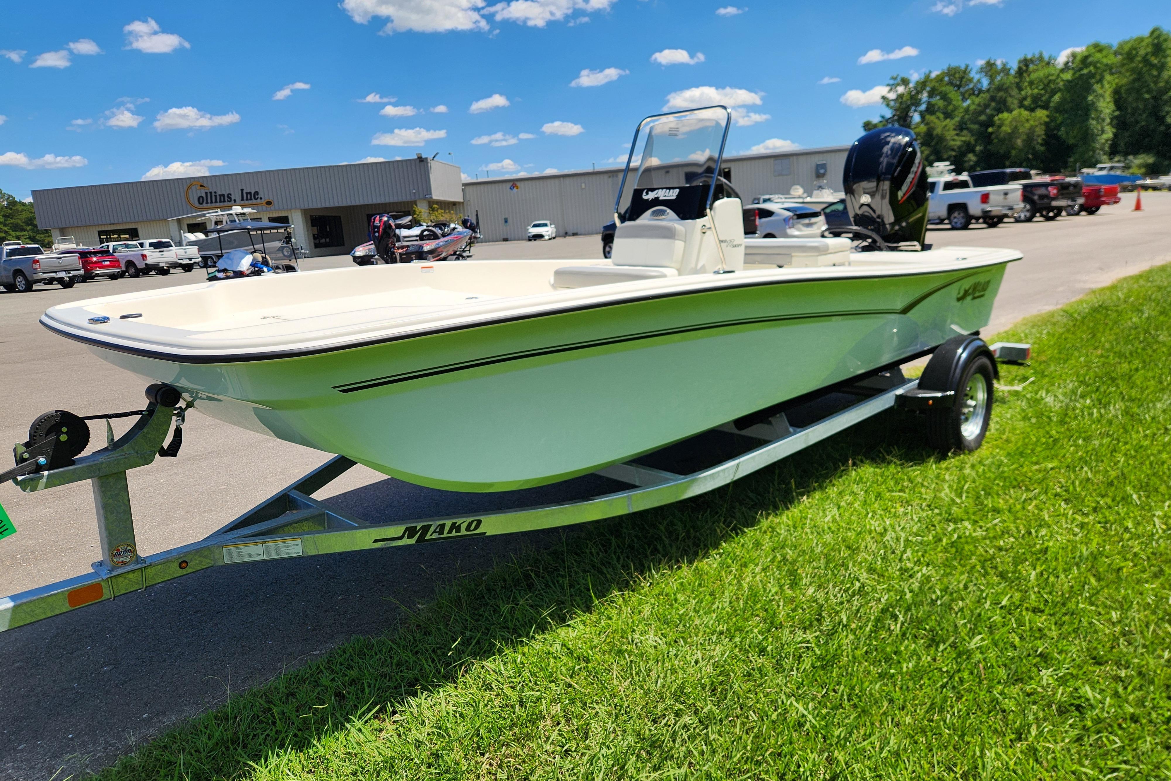 2026 Mako Pro Skiff 17 CC boat on trailer, parked on grass near dealership.