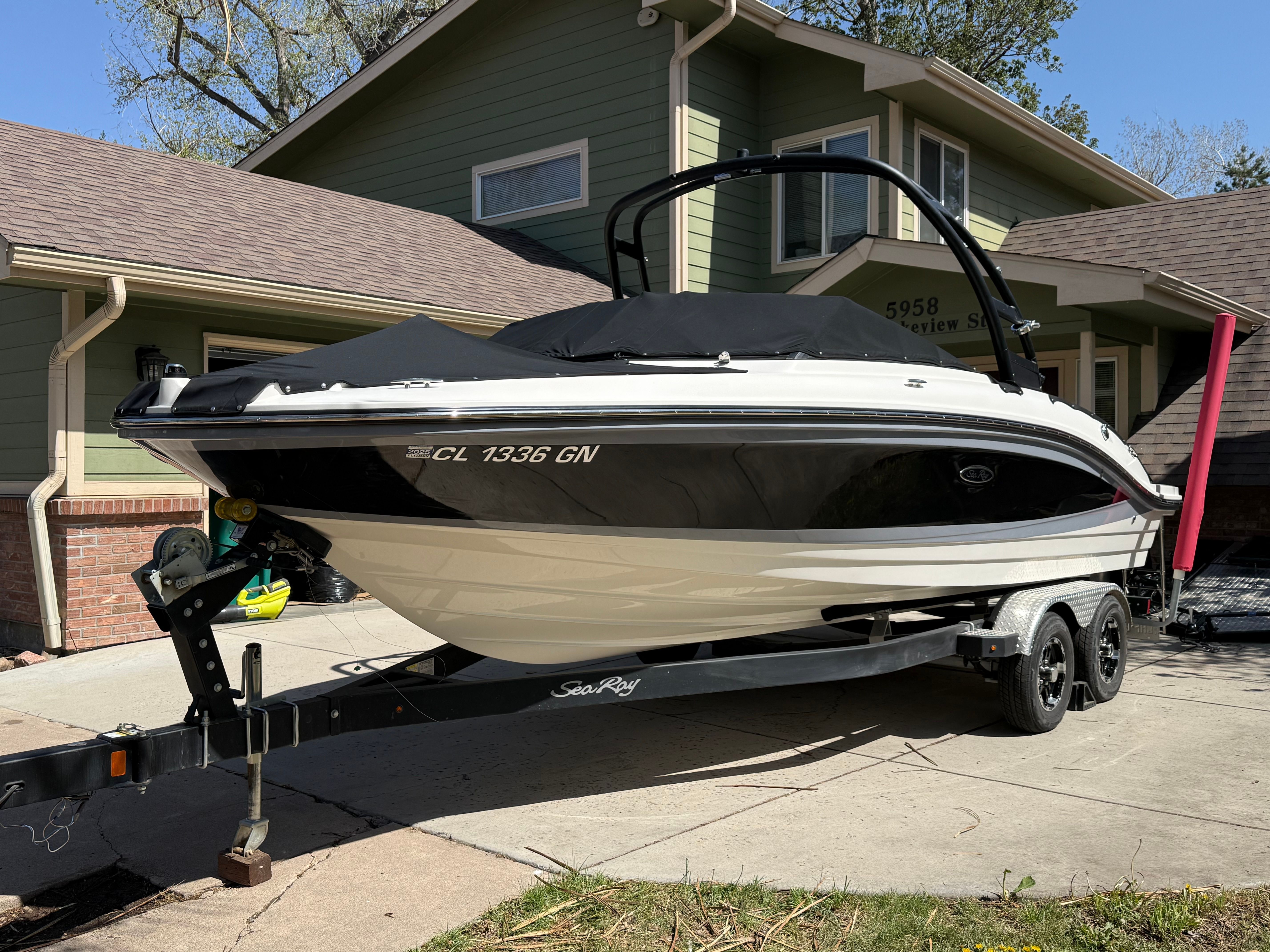 2022 Sea Ray SPX 210 boat on trailer in front of house.