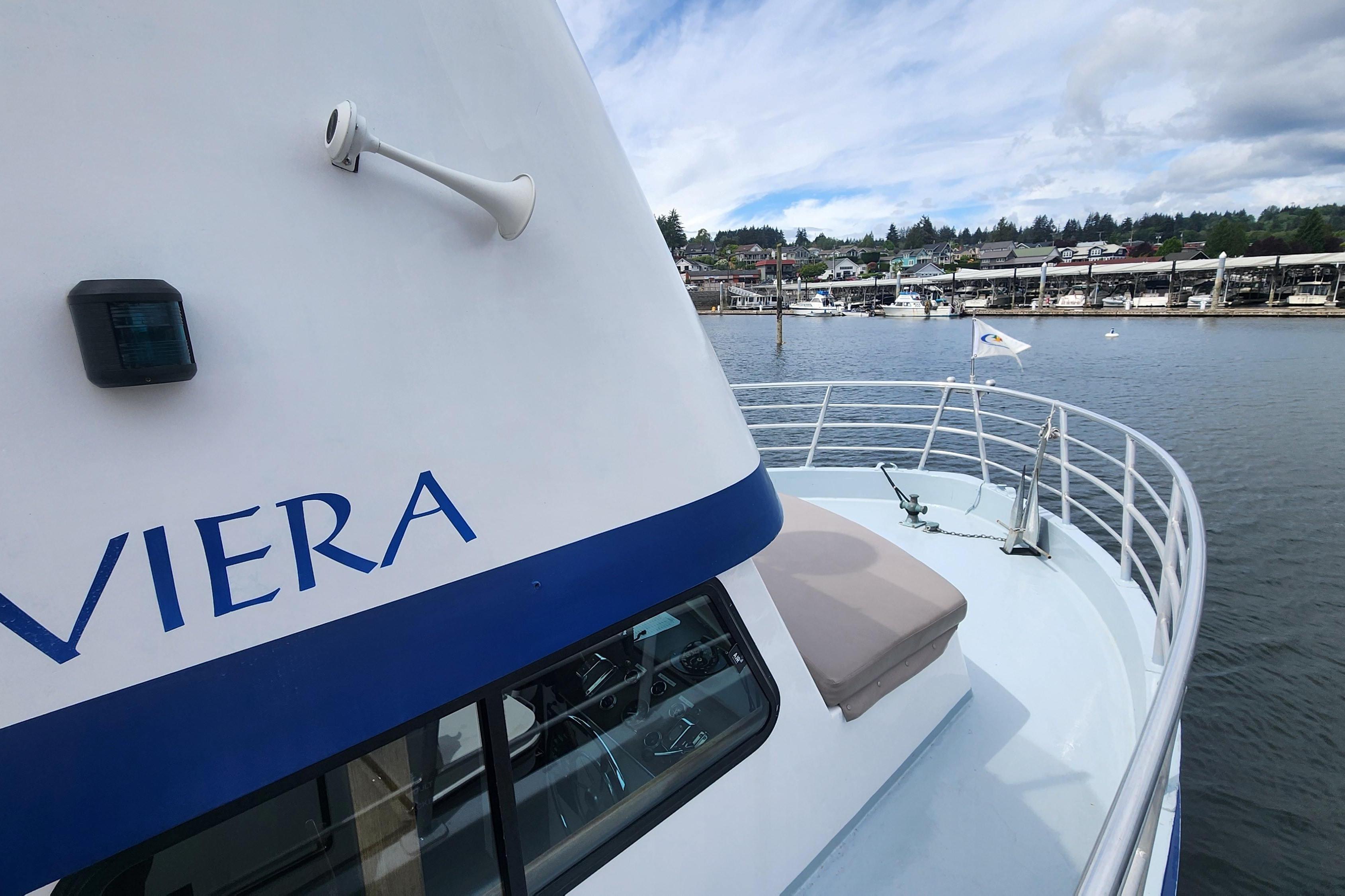1964 Grandy Tour Boat on calm waters, featuring a sleek design and scenic marina backdrop.