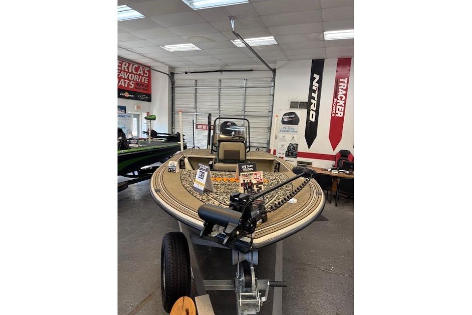 2025 Mako 18 Pro Skiff Backwater Edition displayed in showroom with promotional signs.