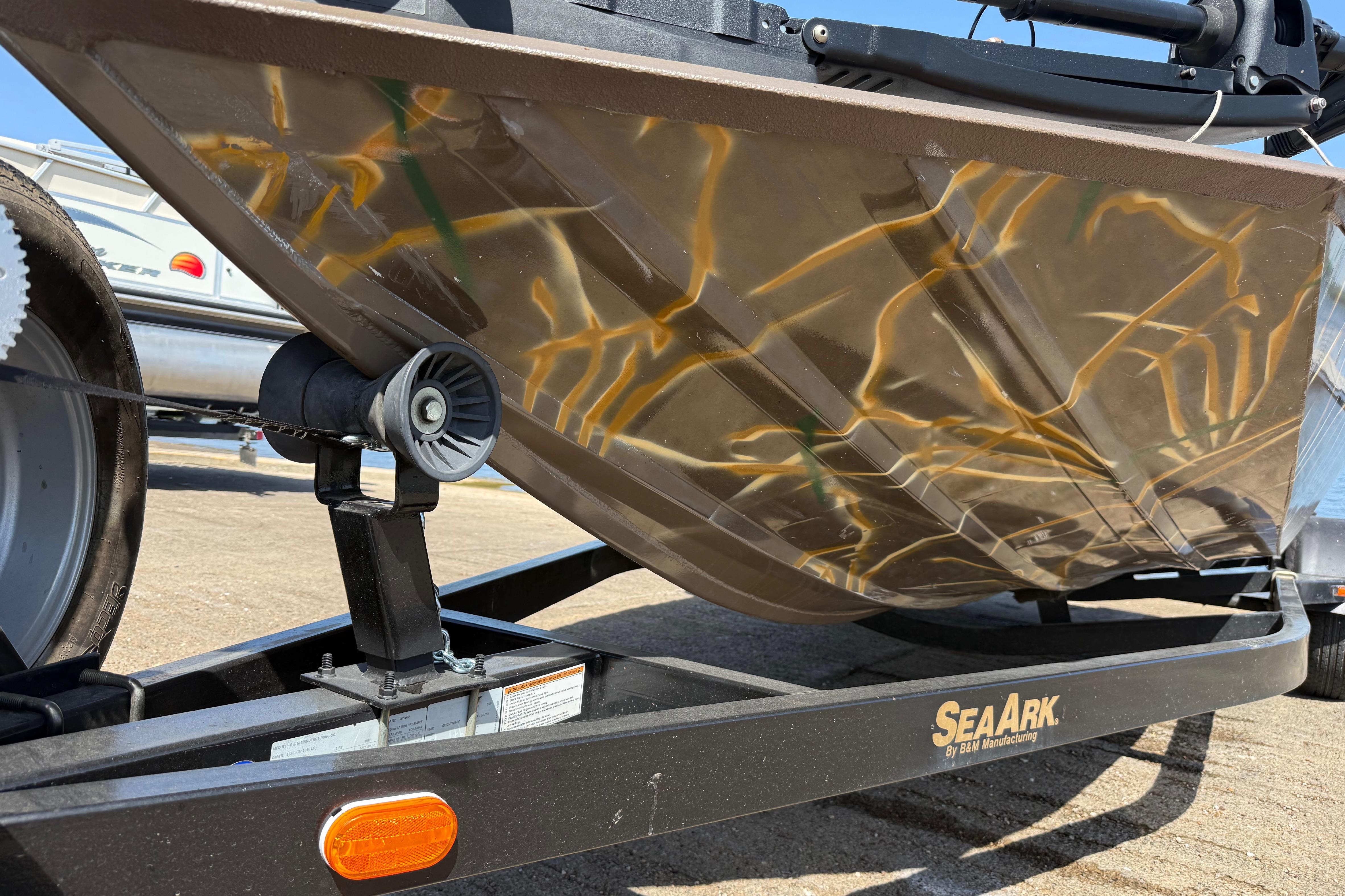 2010 SeaArk Stealth 190 boat hull on trailer, showcasing camouflage design.