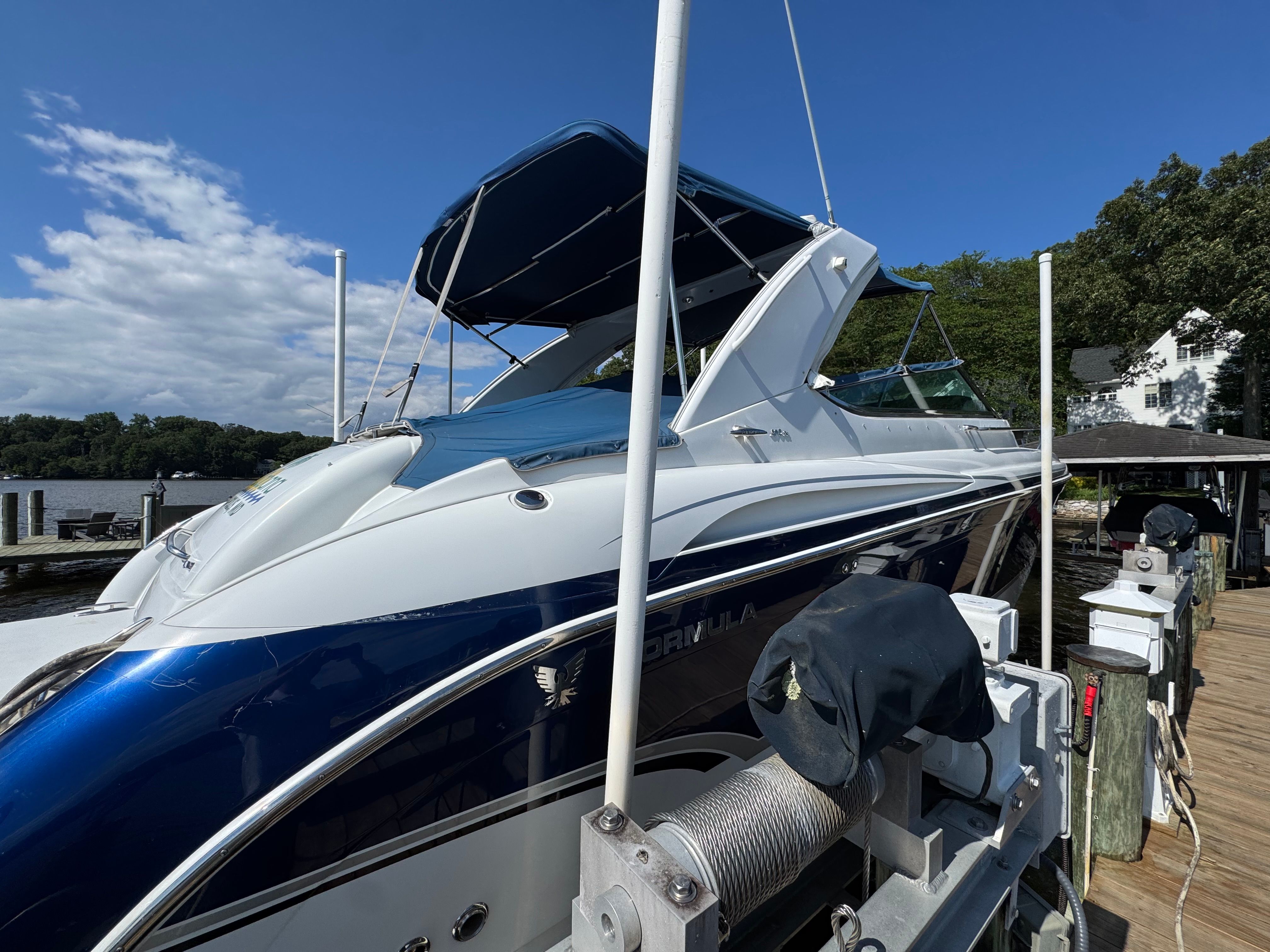 A blue and white motorboat docked at a wooden pier.