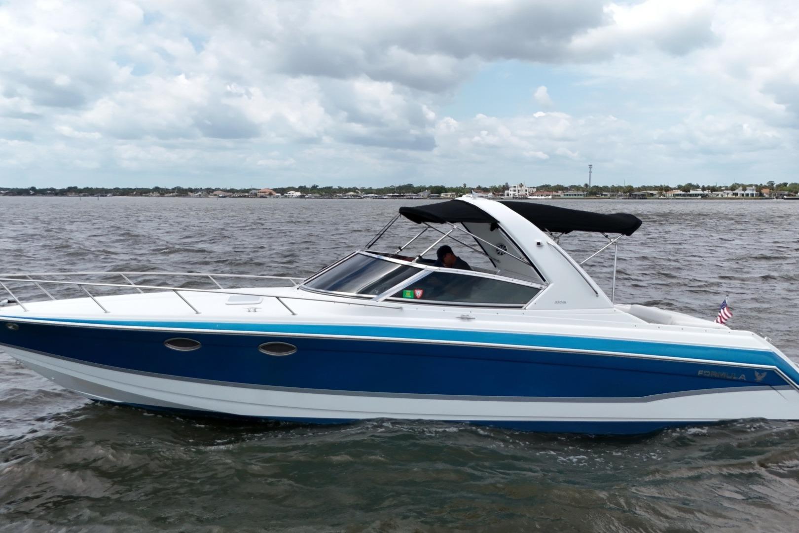 2007 Formula 330 Sun Sport boat cruising on open water under cloudy skies.