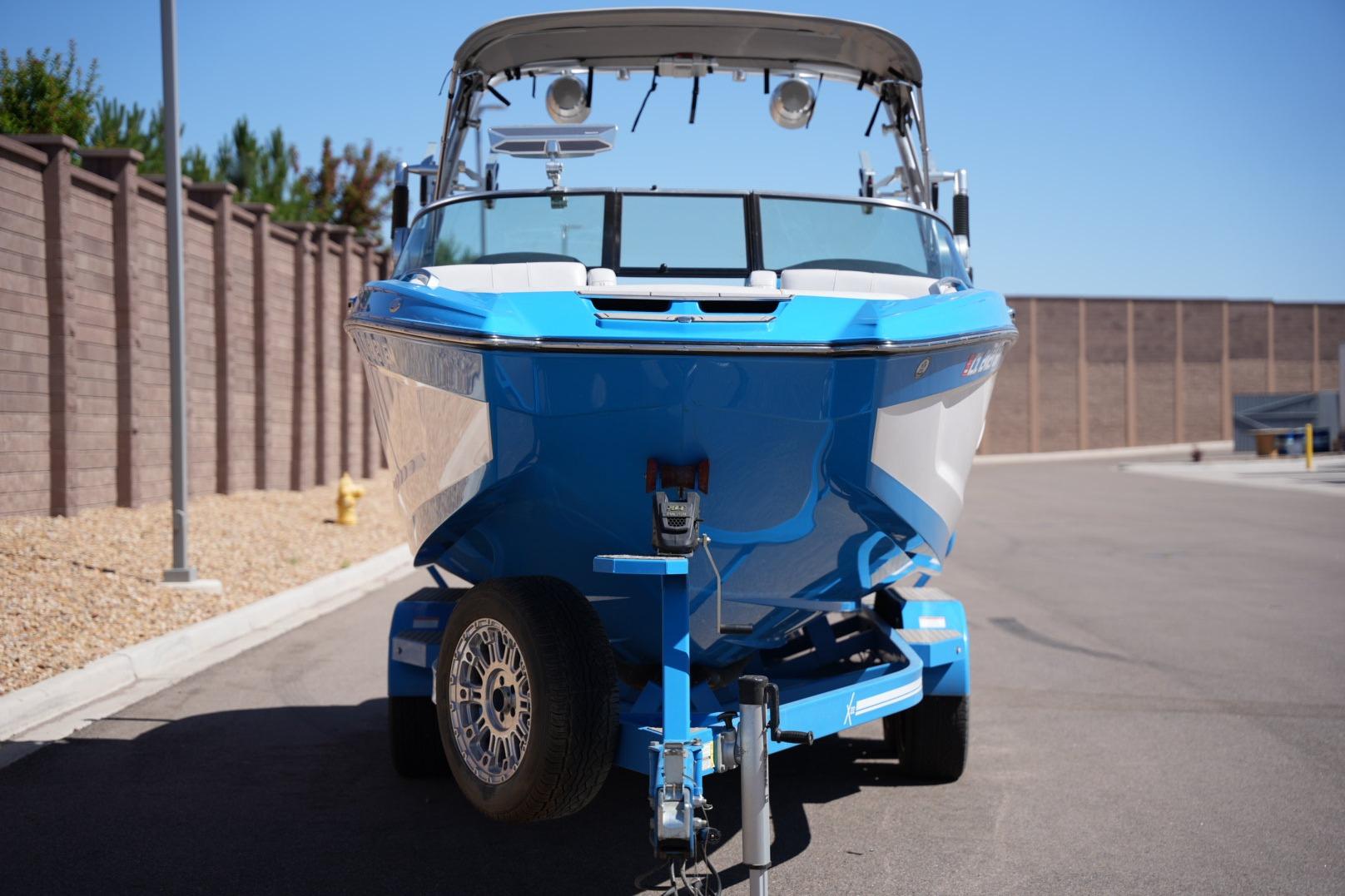 2020 MasterCraft X22 boat on trailer, parked on sunny street.